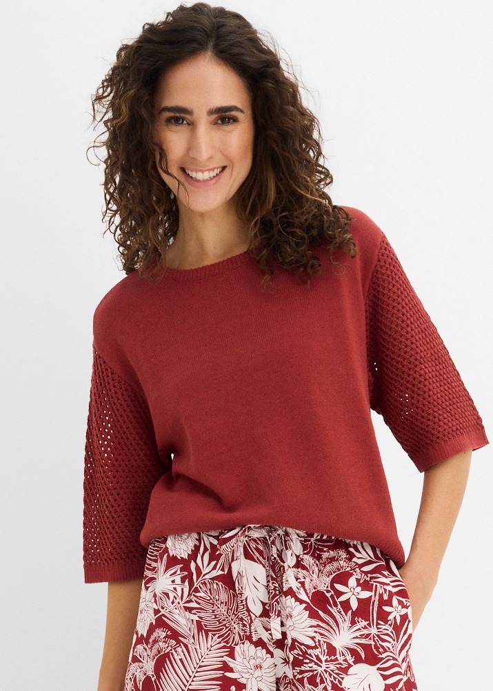 Roter Strickpullover mit halblangen Ärmeln kombiniert mit gemusterter Hose in Weiß-Rot.