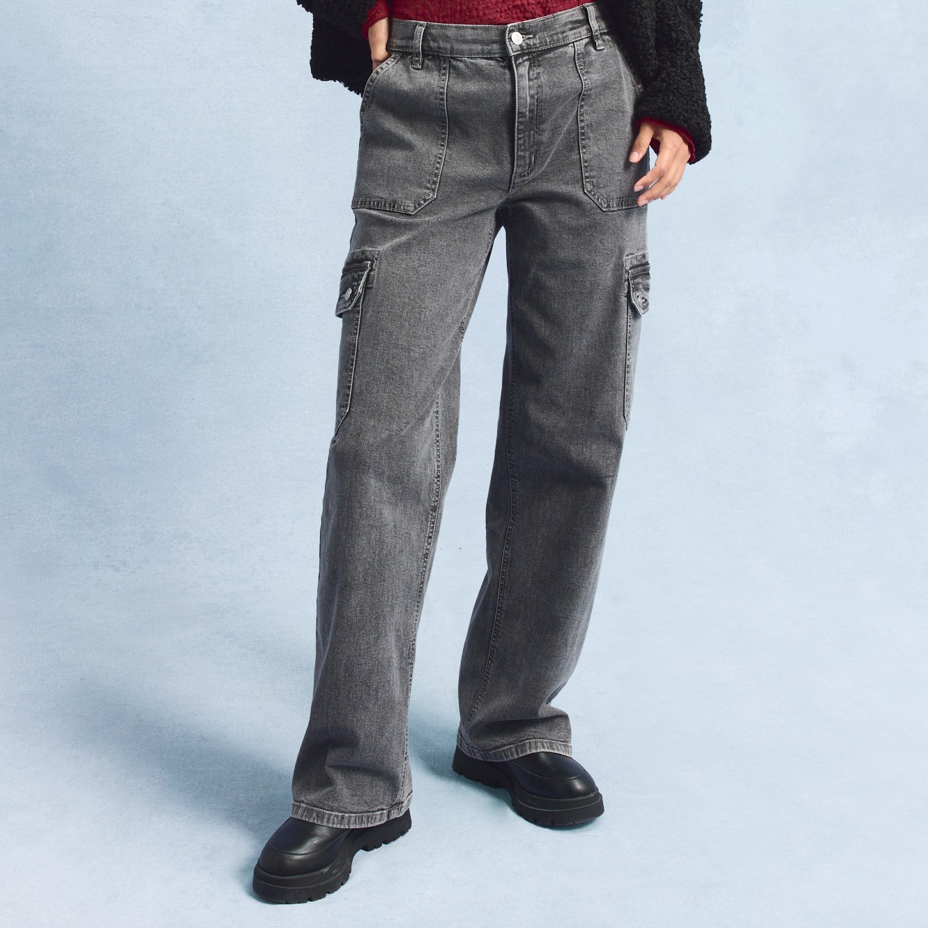 Graue Cargojeans mit geräumigen Seitentaschen, kombiniert mit schwarzen Schuhen.