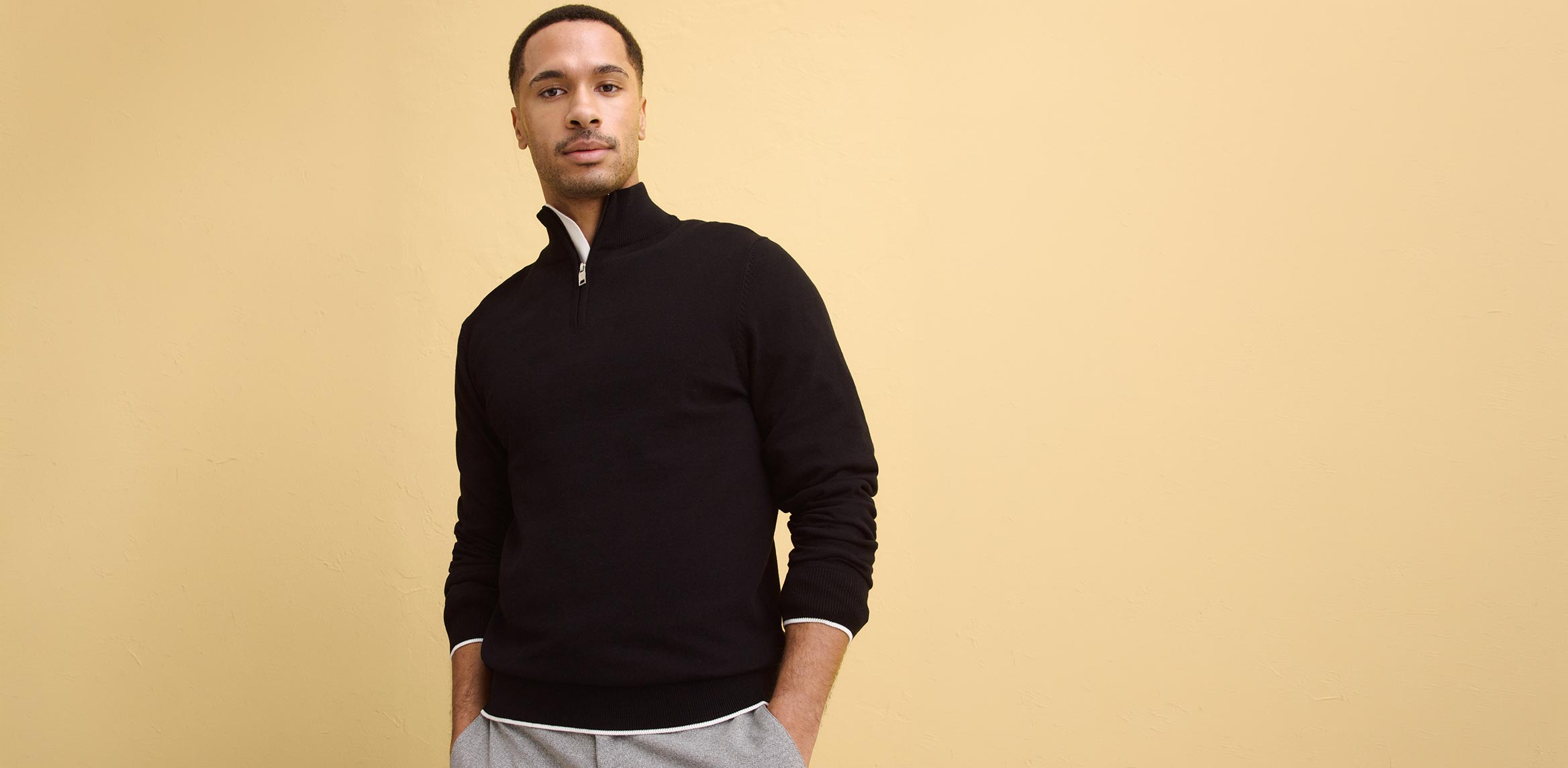 Schlichter, dunkler Pullover mit Stehkragen.