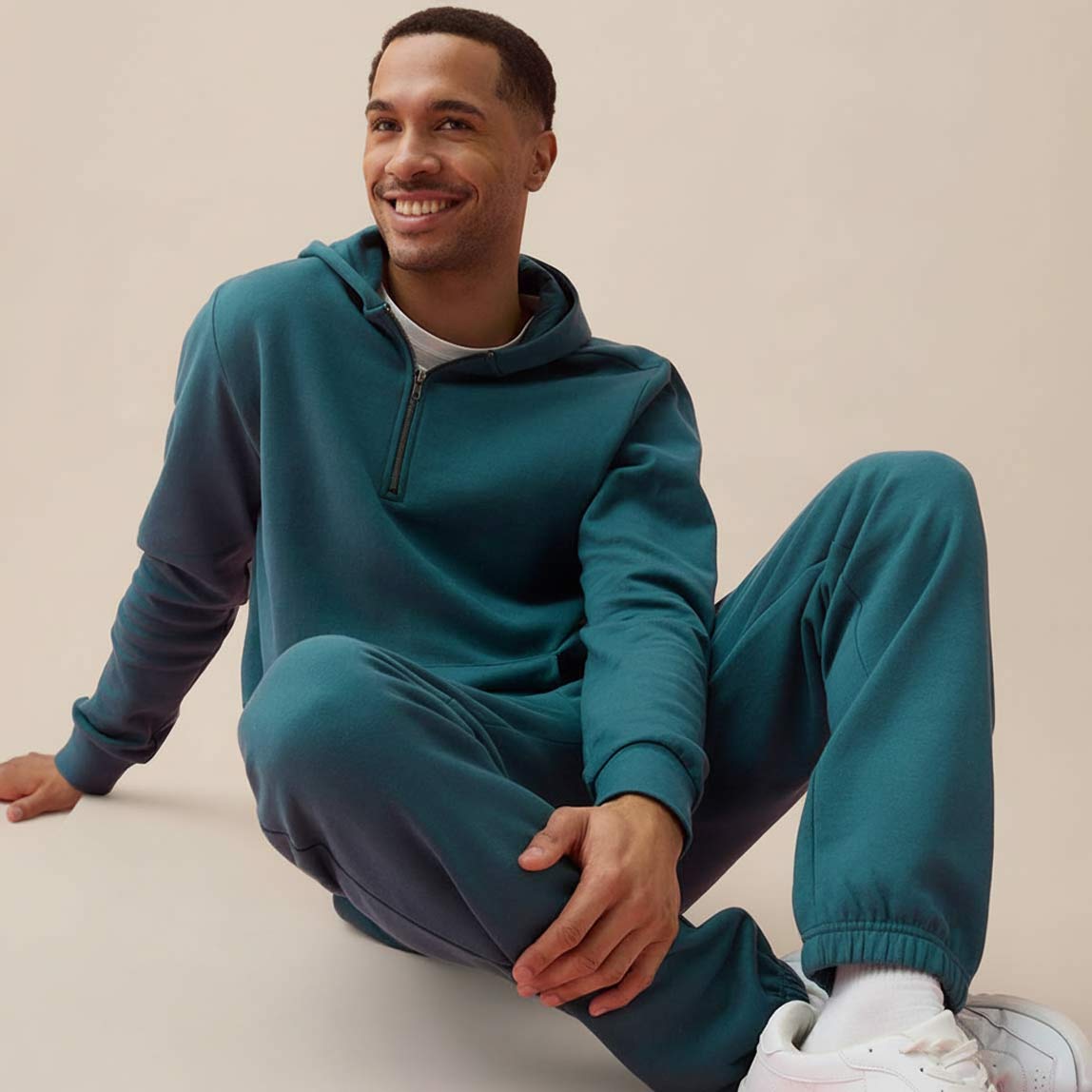 Bequemer türkisfarbener Trainingsanzug. Dazu weiße Sneakers.