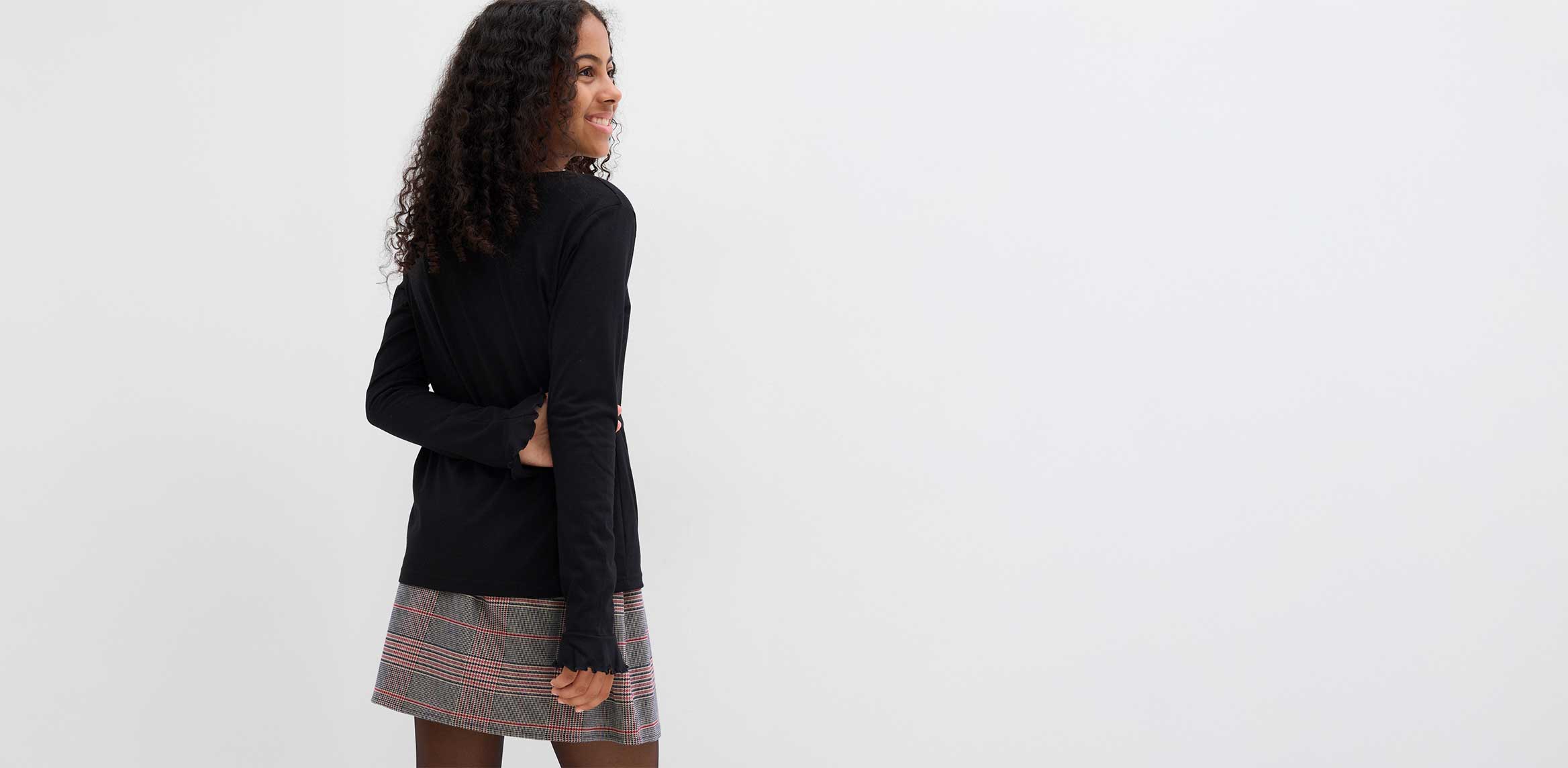 Karierter Rock und Langarmshirt.