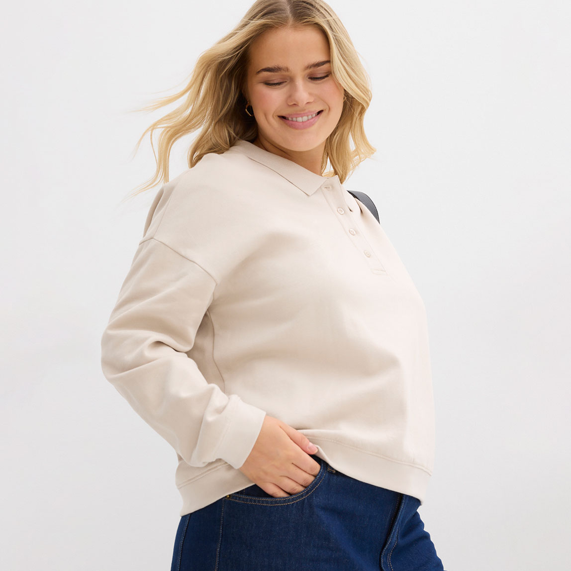 Beiges Sweatshirt kombiniert mit klassischer Jeans.