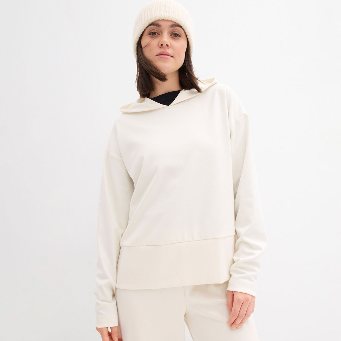 Weißer Kapuzenpullover mit passender Mütze.