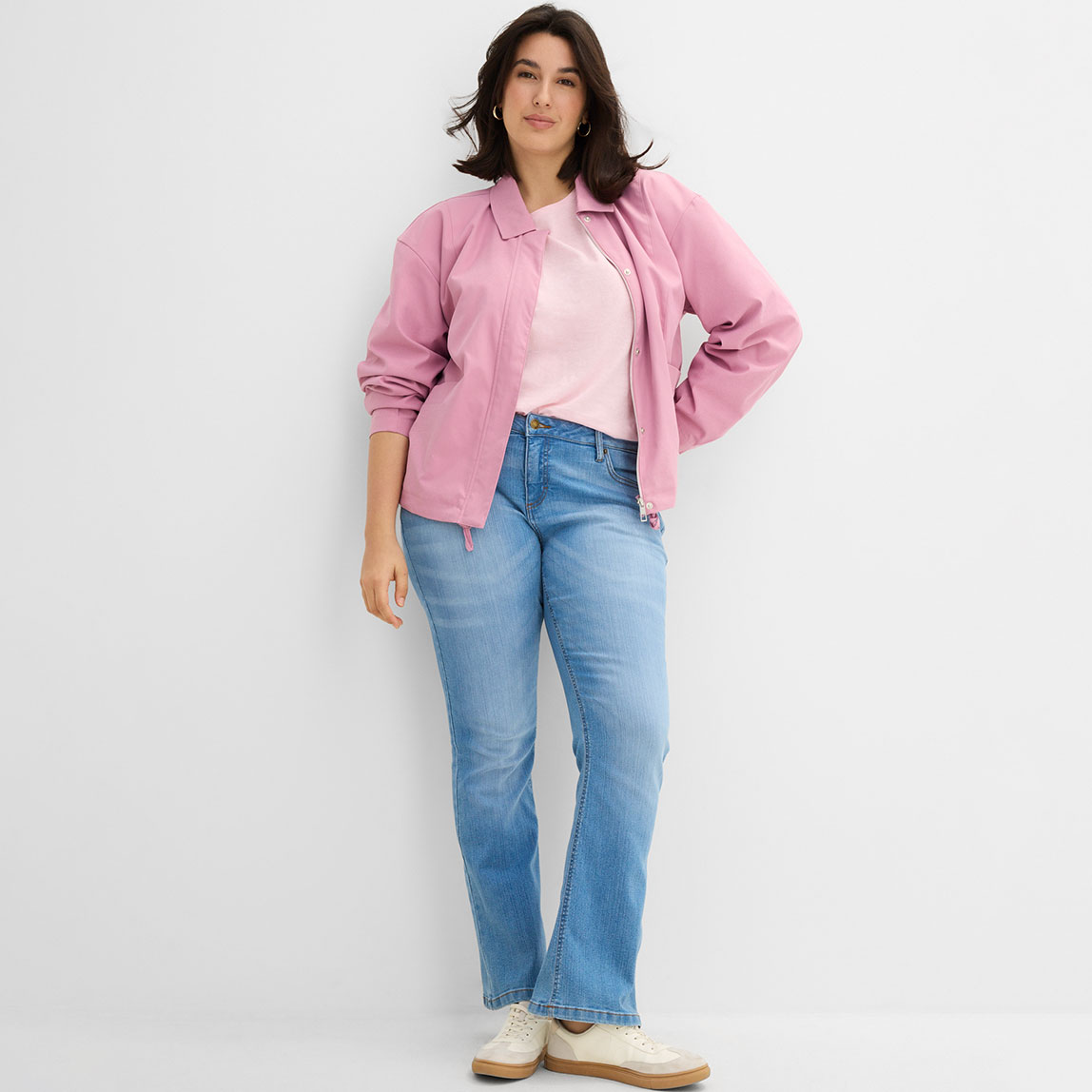 Lässiger Look mit rosa Blouson und hellblauer Jeans.