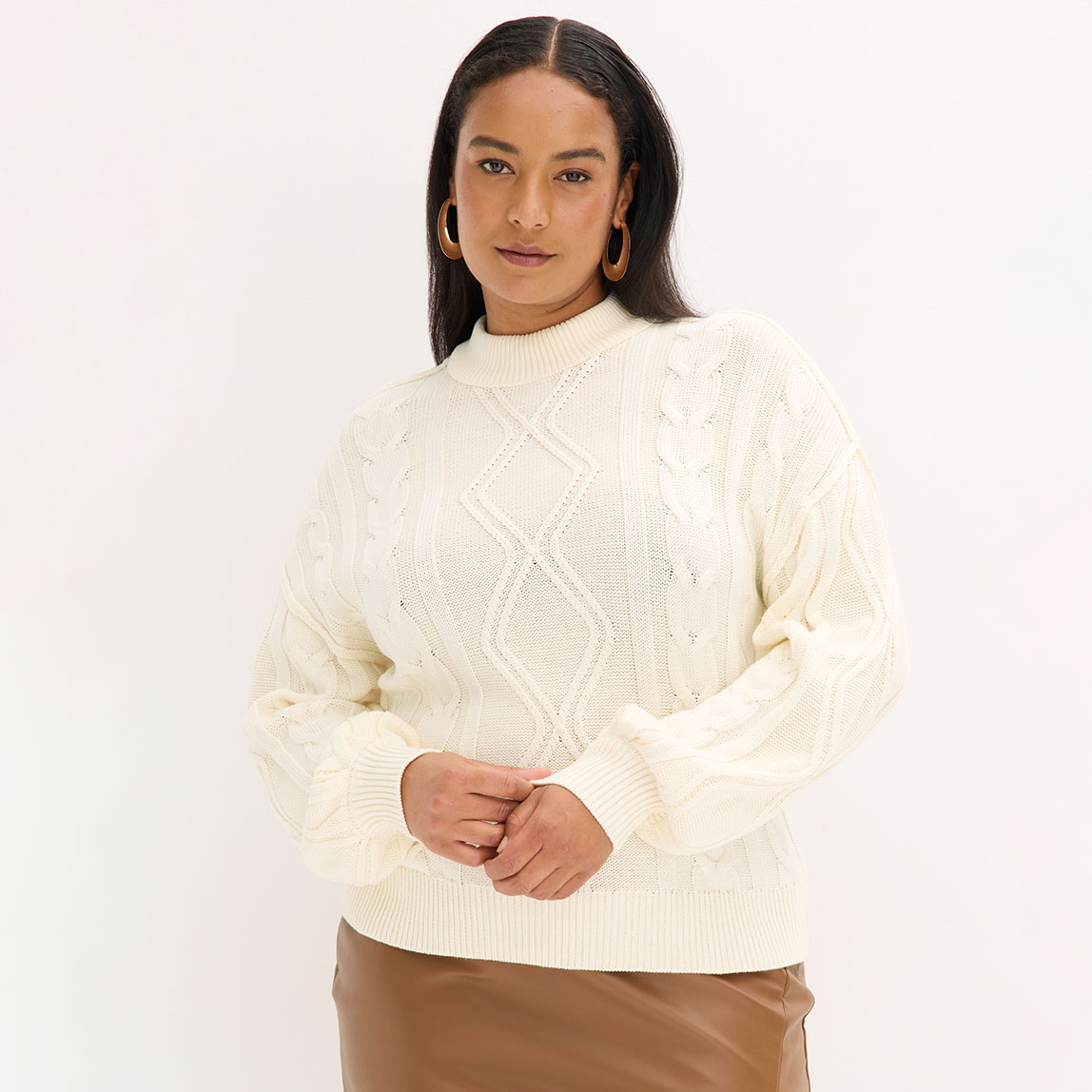 Weißer Strickpullover mit Zopfmuster und Rollkragen. 