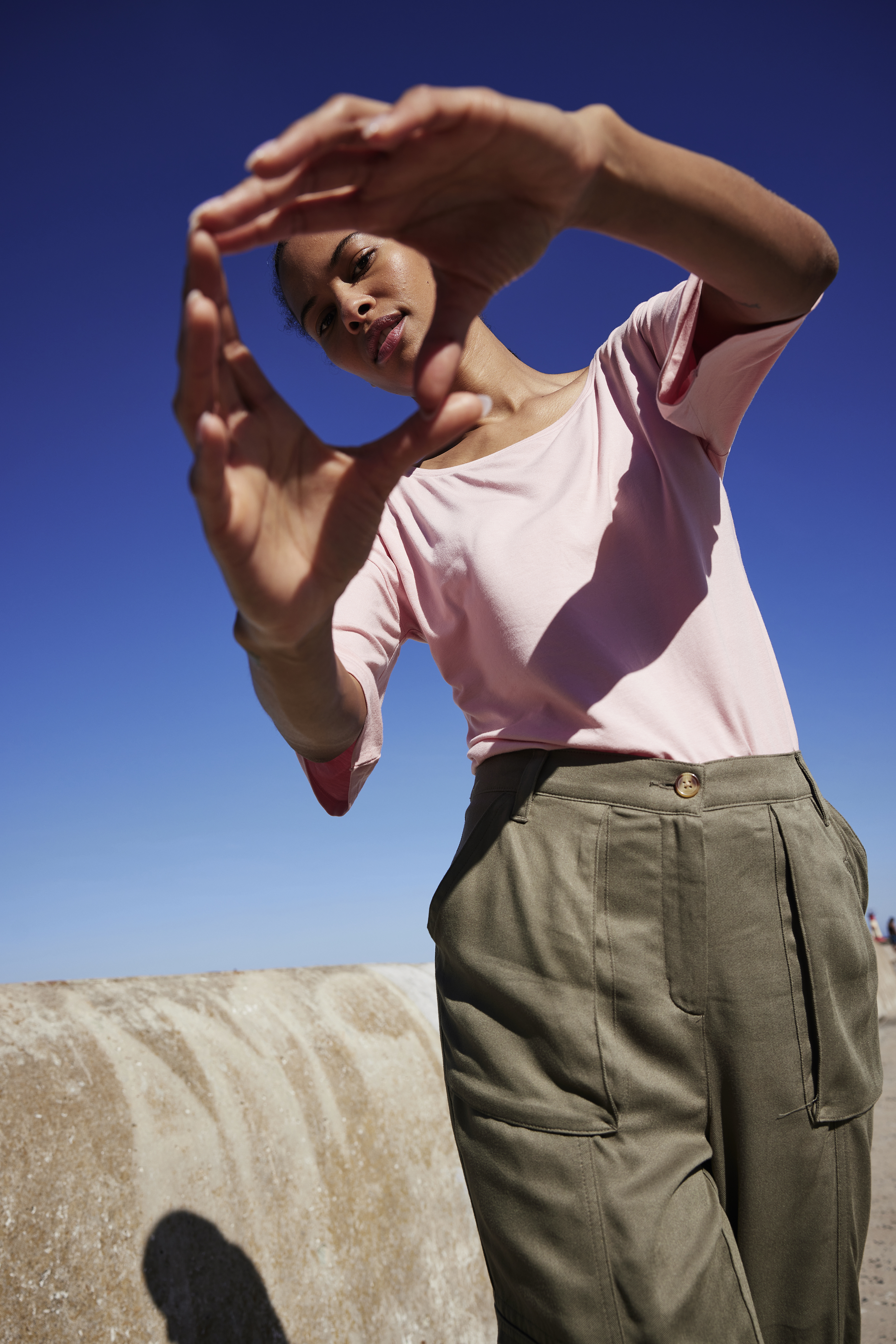 Rosa T-Shirt und olivgrüne Cargohose: Lässiger Sommerlook für sonnige Tage im Freien.