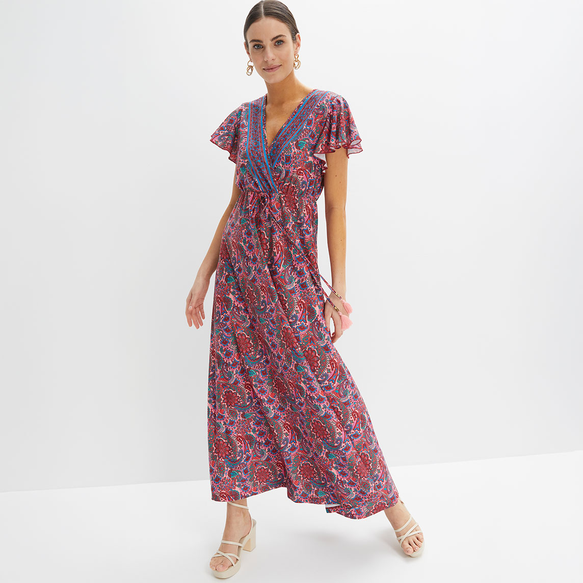 Farbenfrohes Maxikleid mit Paisley-Muster, V-Ausschnitt, kurzen Ärmeln und eleganten Sandalen.
