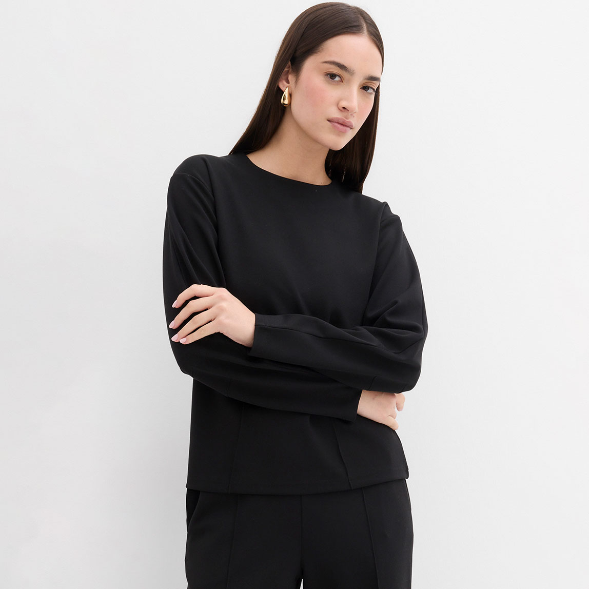Schwarzes Langarmshirt mit rundem Ausschnitt und langen Ärmeln.
