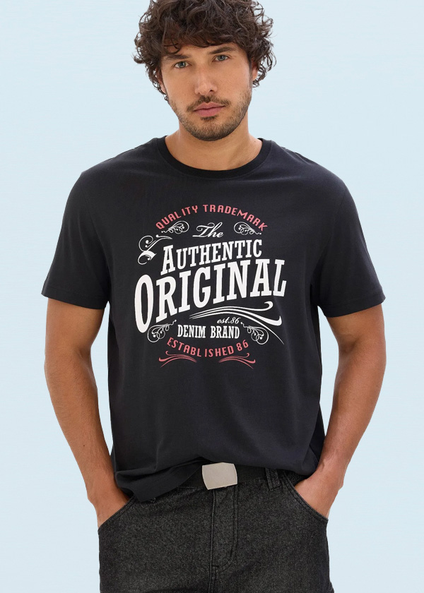 Er trägt ein leuchtend rotes Poloshirt und bequeme blaue Jeans.