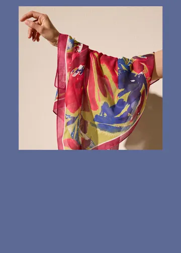 Braune Ohrringe, passende Handtasche, elegantes Tuch und auffällige Kette.