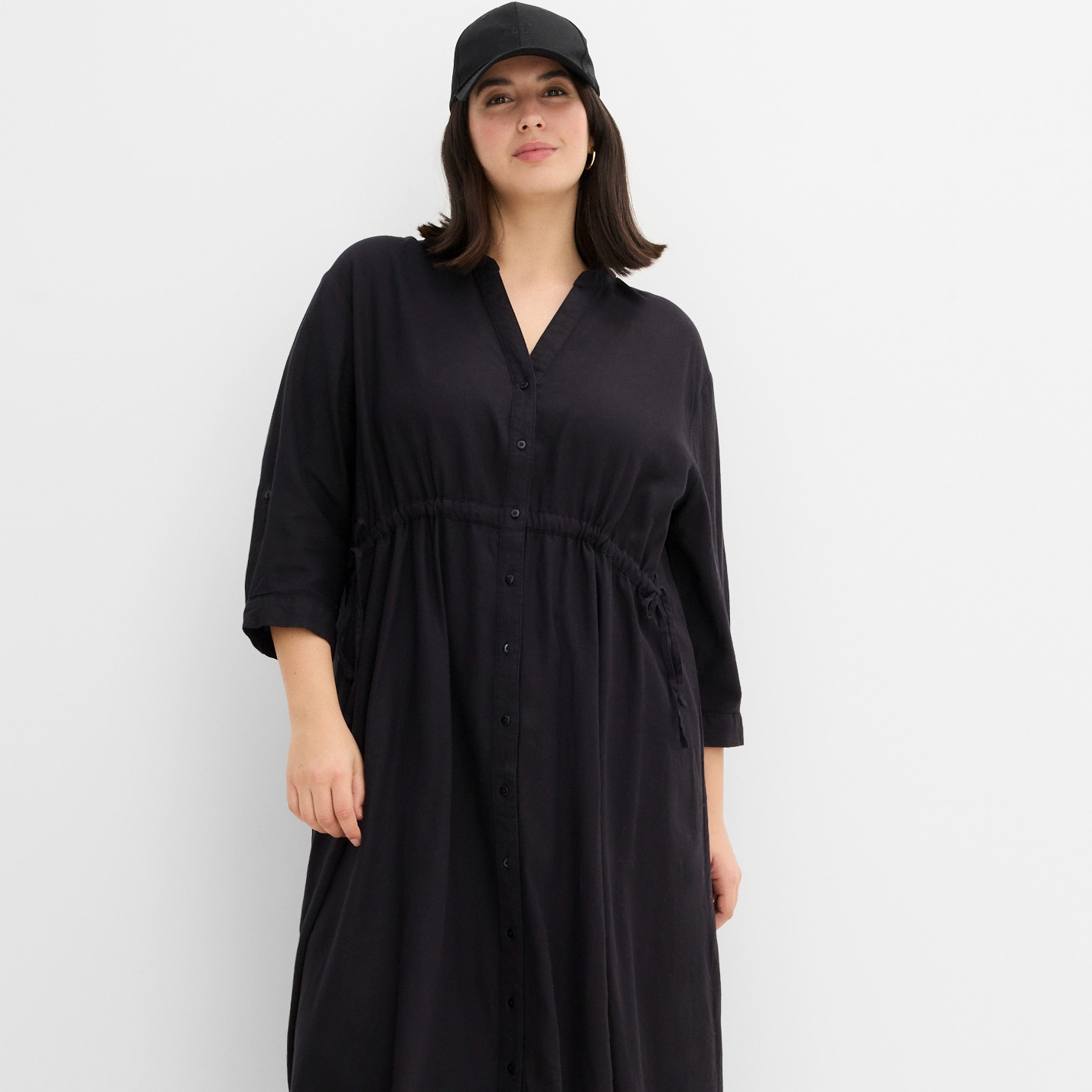 Schwarzes Blusenkleid mit V-Ausschnitt, langen Ärmeln und Knopfleiste.