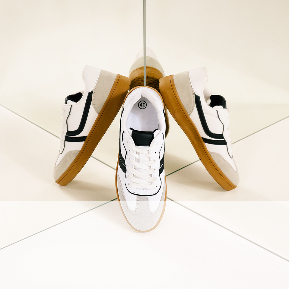 Sportliche Eleganz: Weiße Sneaker mit schwarzen Akzenten und goldenen Seitenstreifen, perfekt für aktiven Lifestyle.