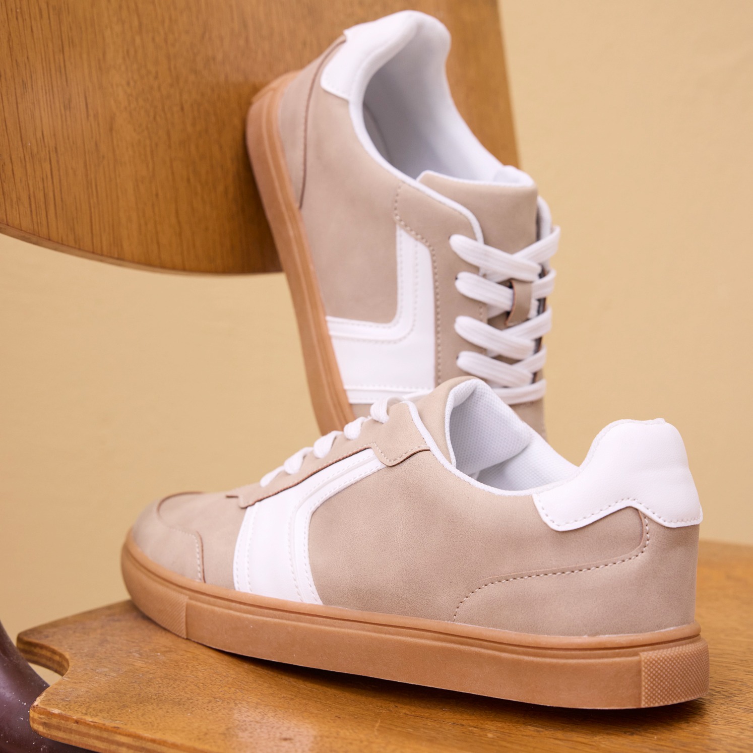 Sneaker in Beige und Weiß mit flacher Sohle.