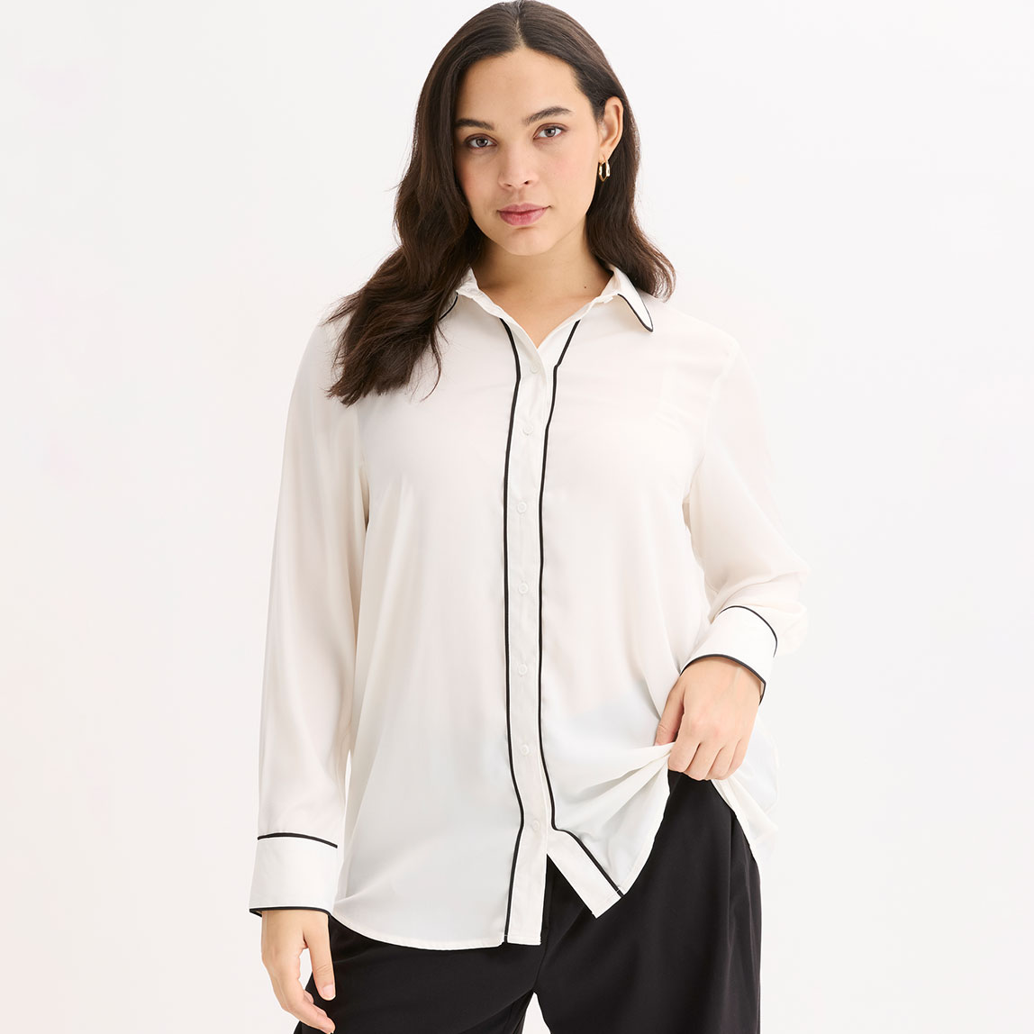 Weiße Bluse mit schwarzer Paspel. Klassischer Hemdkragen und lange Ärmel.