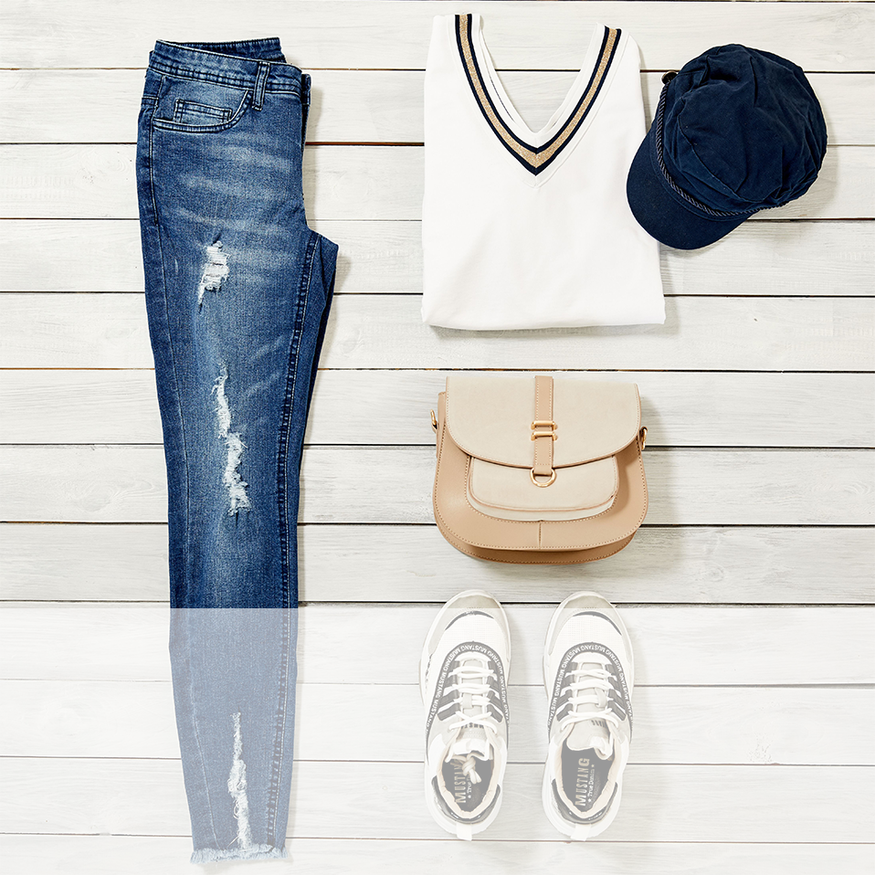 Lässiger Look mit zerrissener Jeans, weißem T-Shirt, Basecap und bequemen Sneakers.