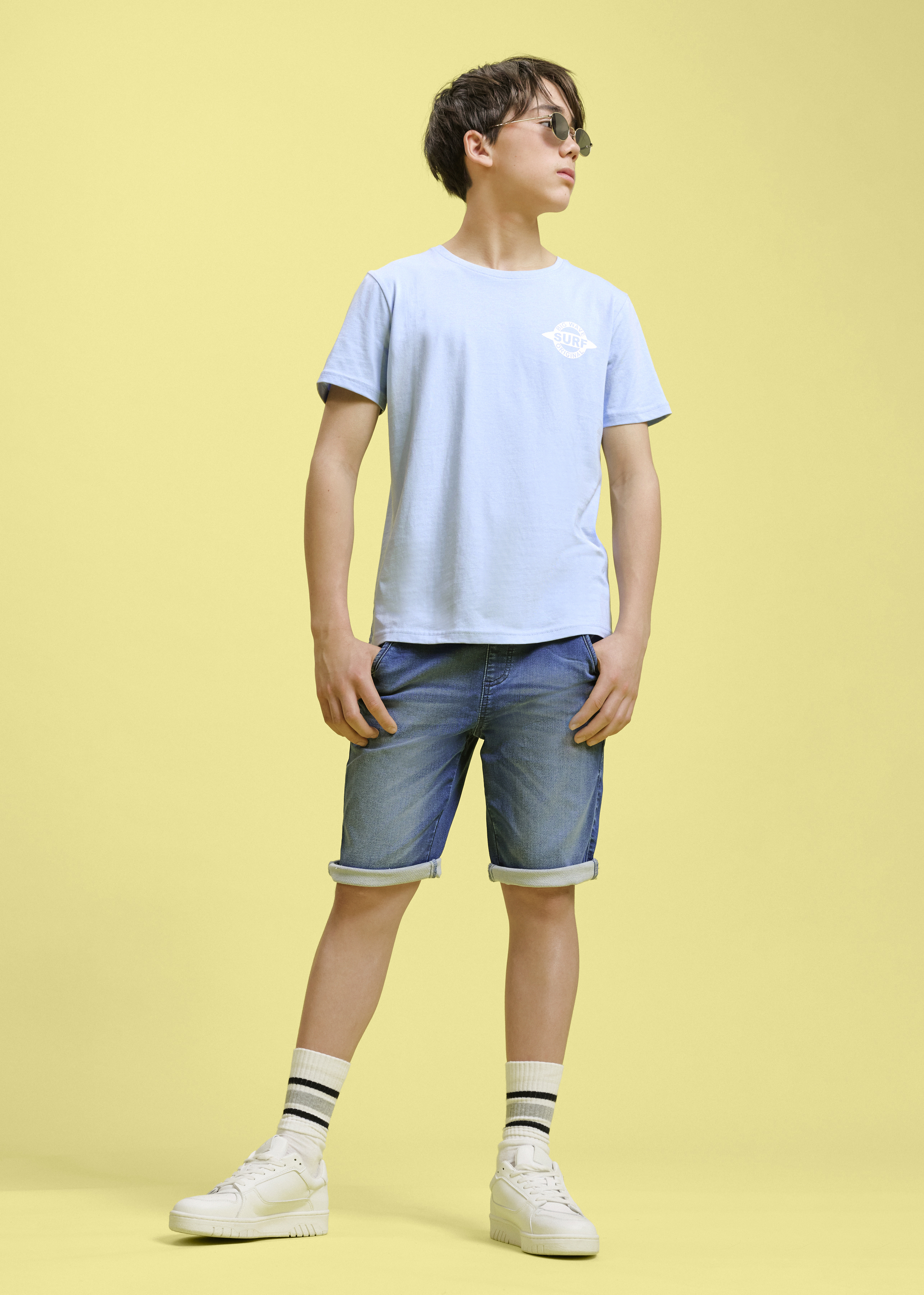 Hellblaues T-Shirt und Denim-Shorts.