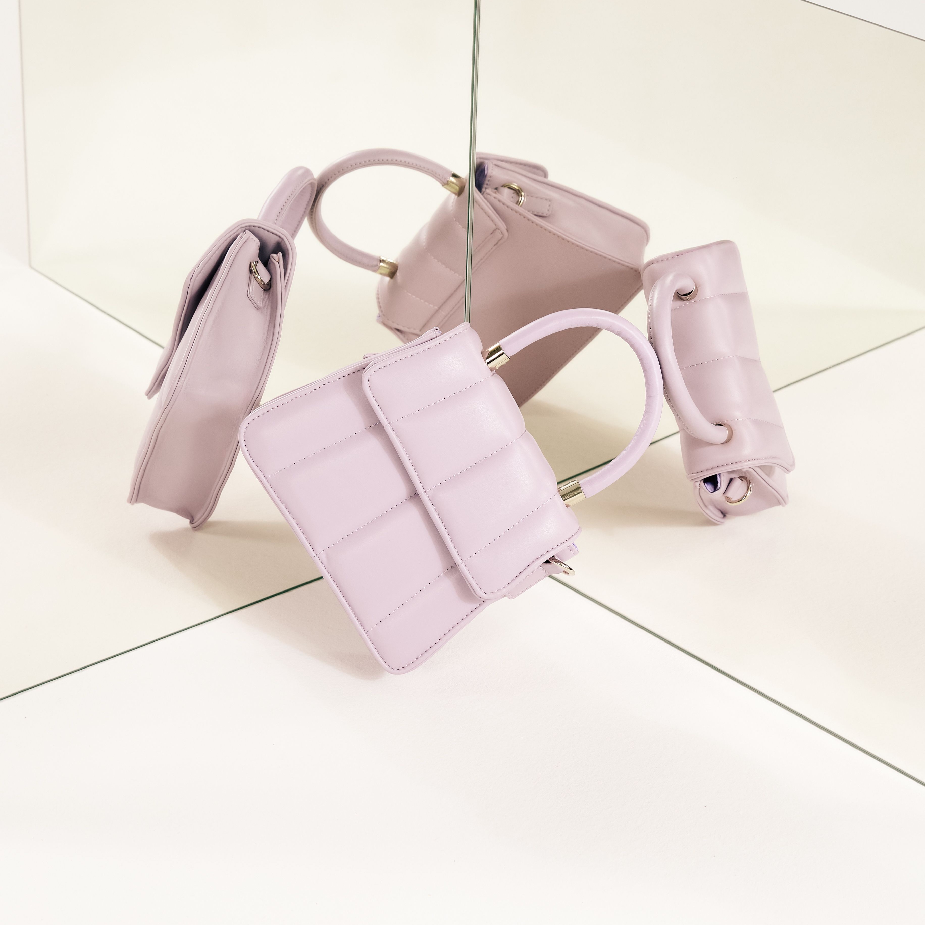 Pastellfarbene Accessoires: Eine zarte Handtasche und ein schlanker Gürtel in sanftem Rosa.