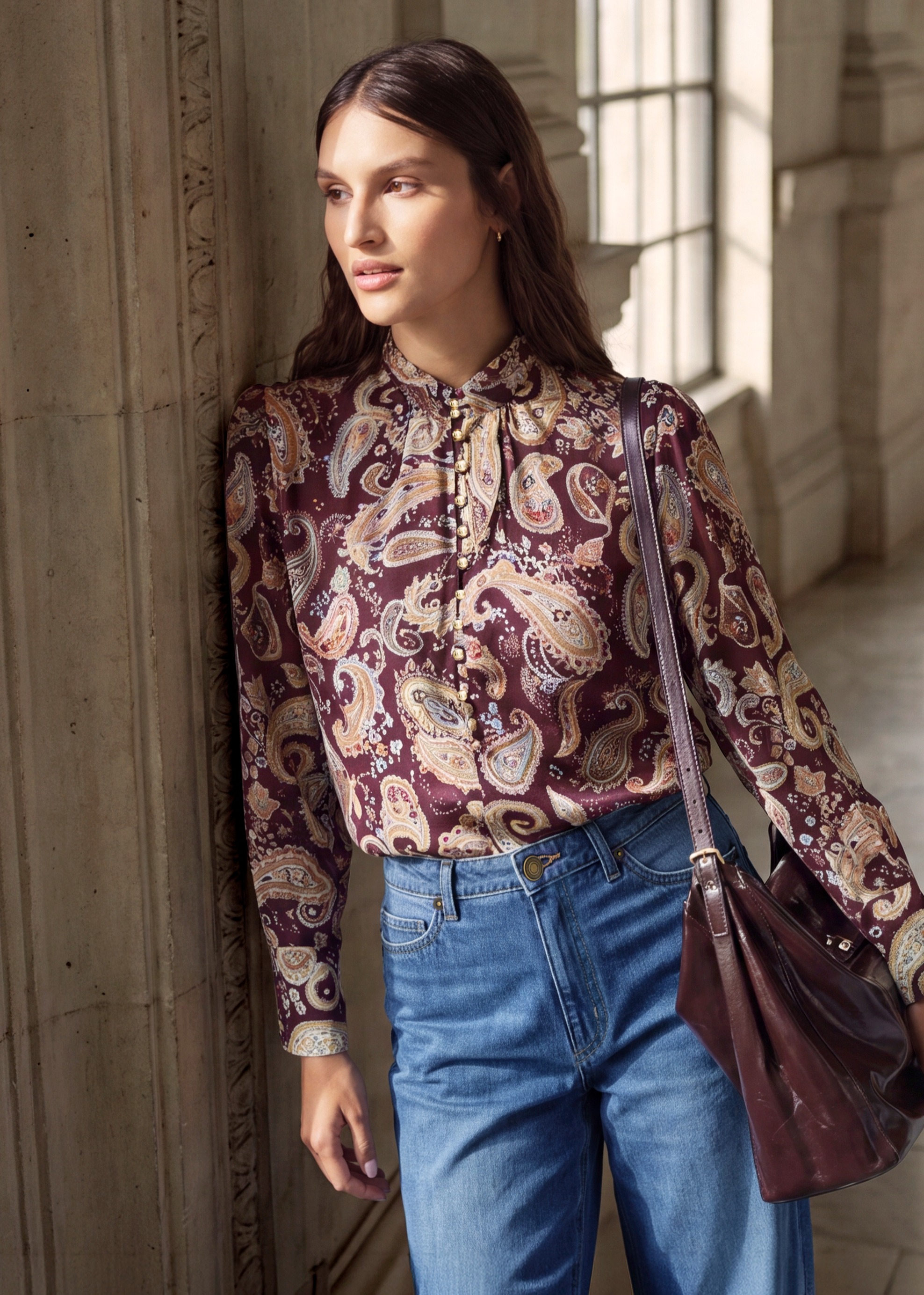 Stilvolle Paisley-Bluse mit Schleife, dazu weite Jeans und passende Ledertasche.
