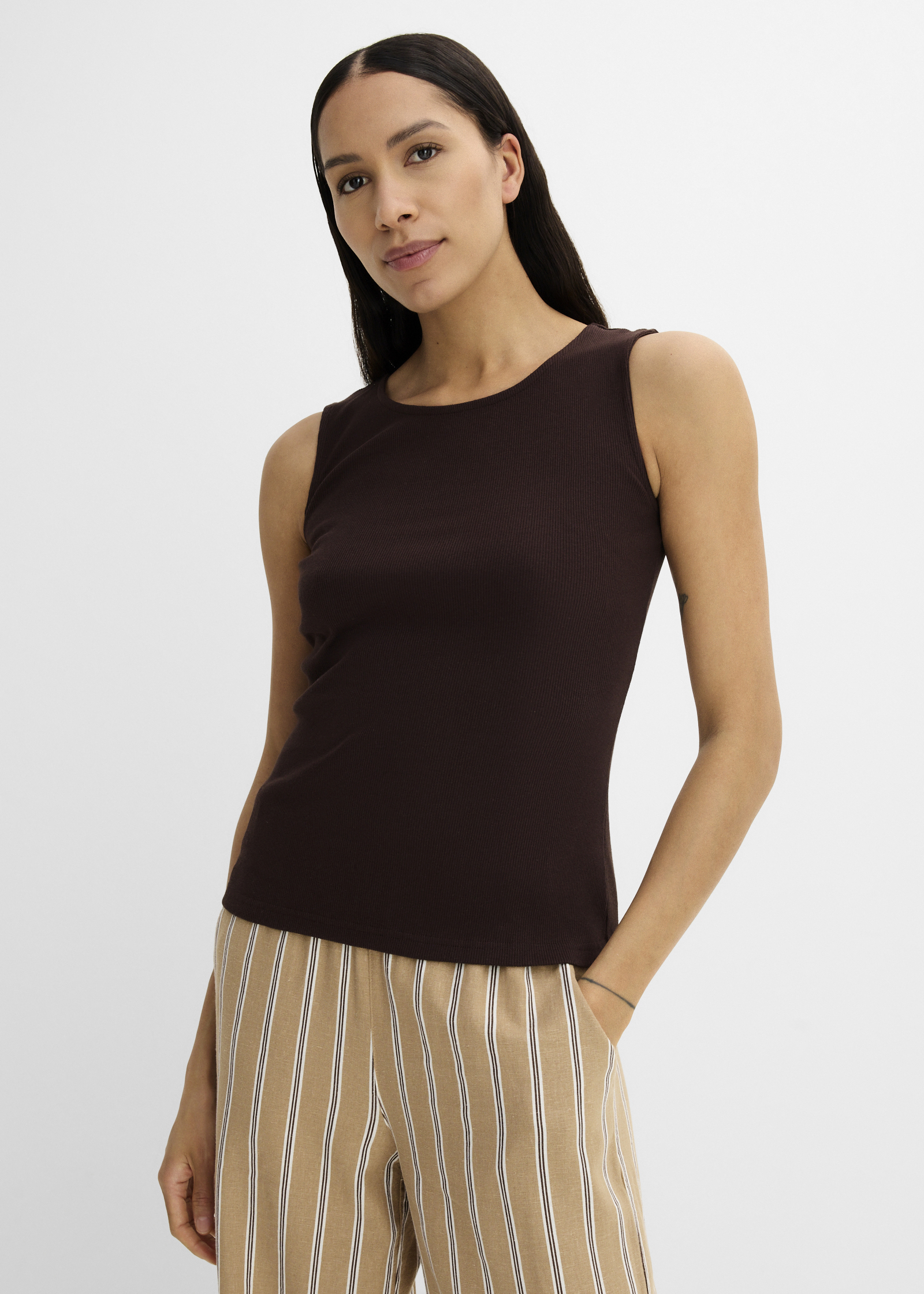Dunkelbraunes Tanktop und gestreifte Hose für einen entspannten, stilvollen Look.