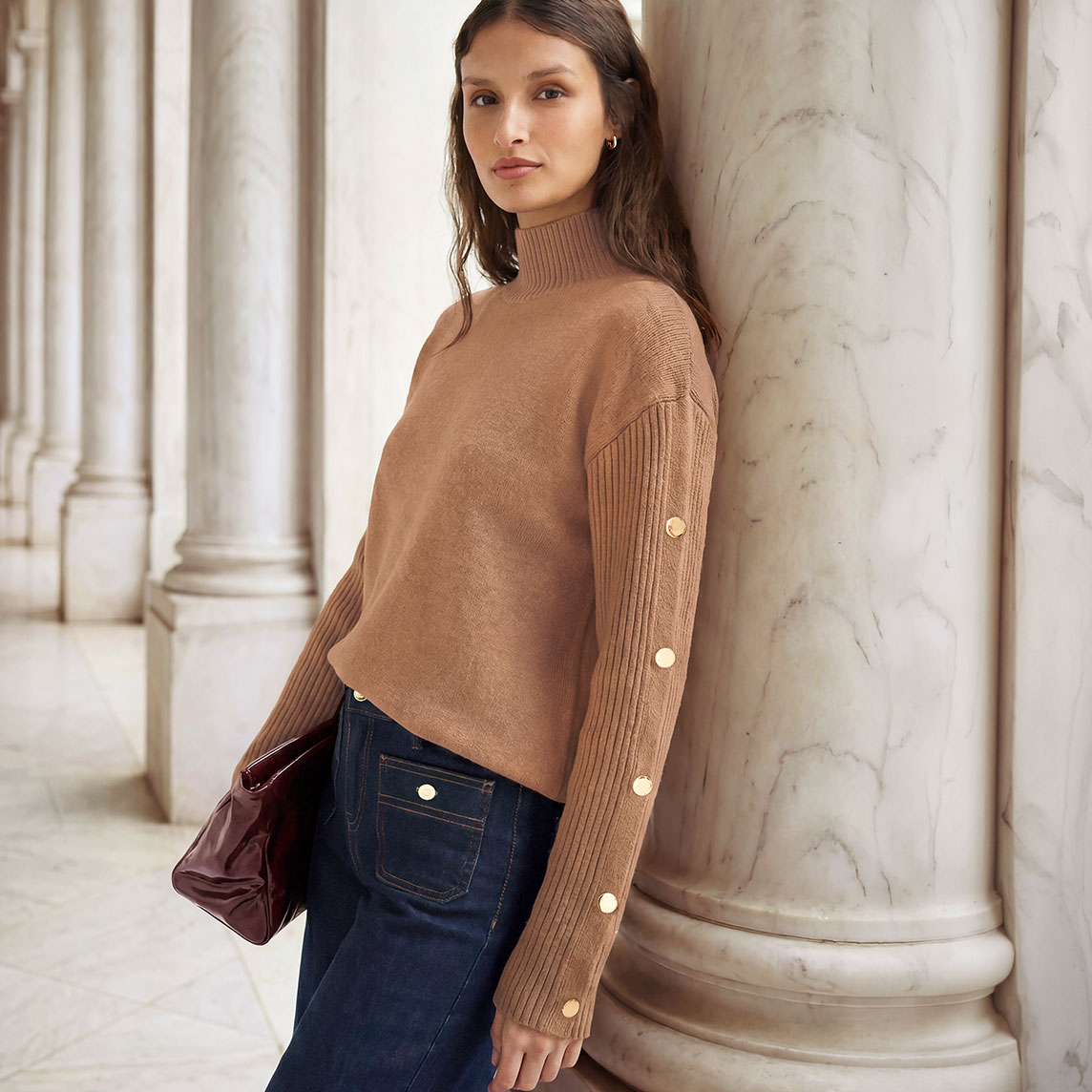 Modischer Rollkragenpullover mit Knöpfen, weite Jeans und elegante Tasche.