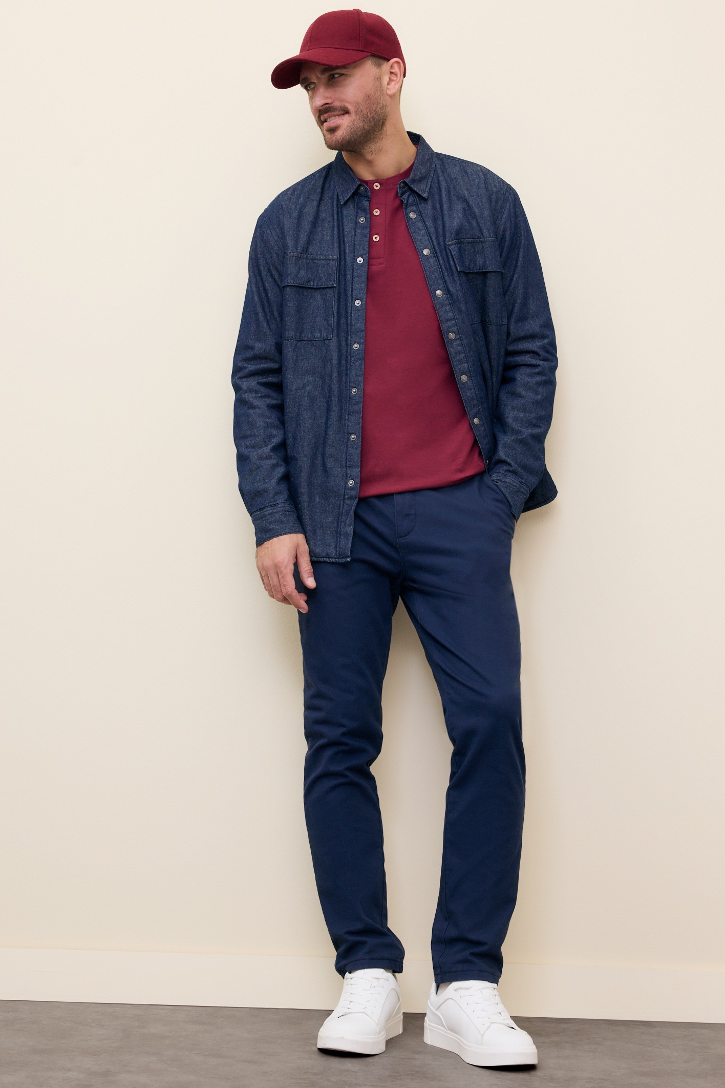 Jeanshemd über Shirt, dunkle Hose und weiße Sneakers.