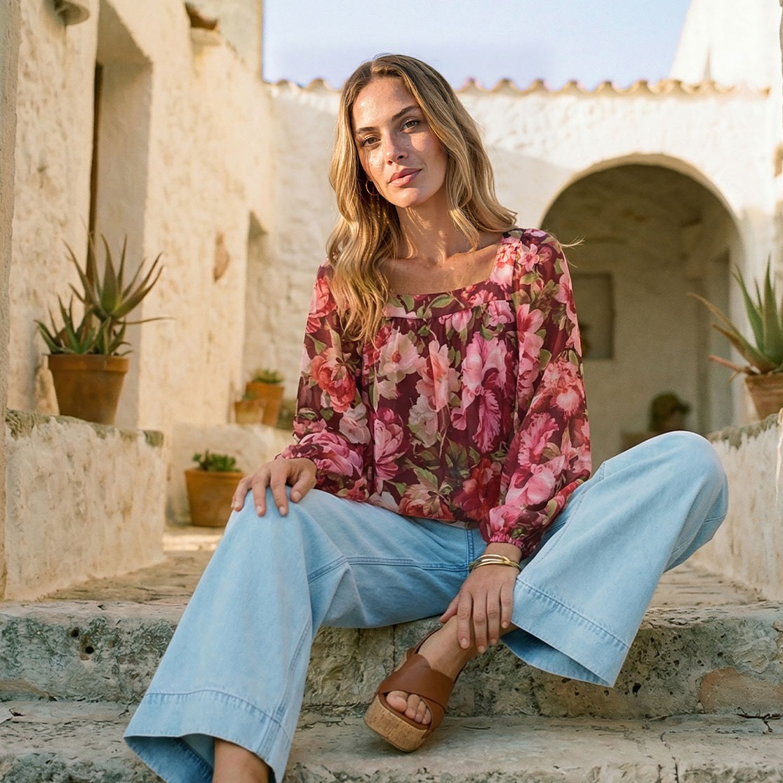 Rosafarbenes Rüschen-Top, helle weite Jeans und eine elegante braune Tasche.