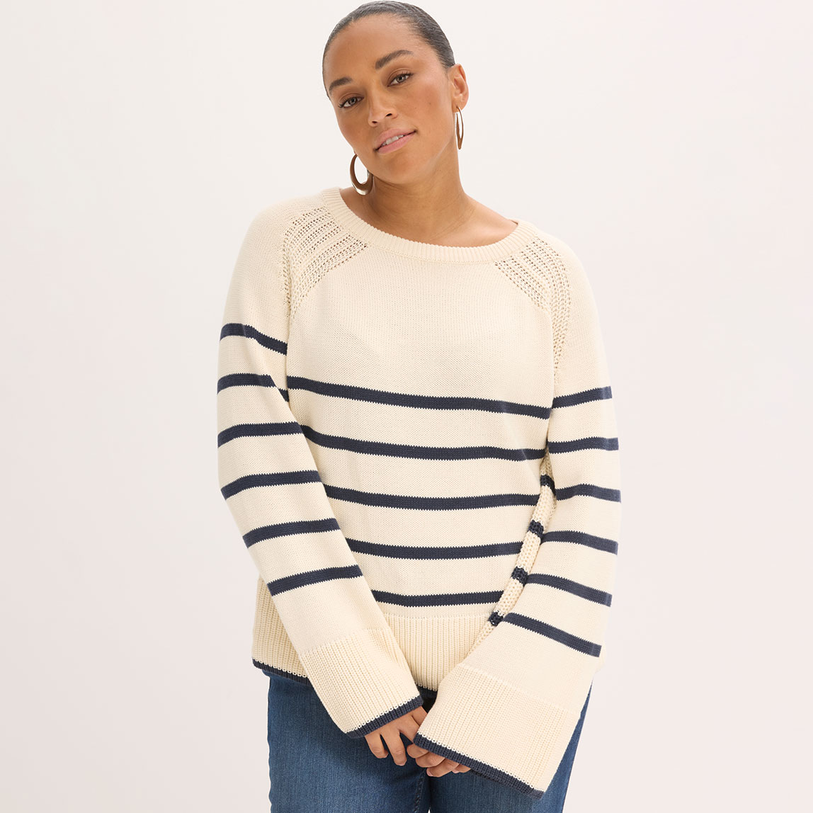 Gestreifter Strickpullover in Weiß und Blau, kombiniert mit blauen Jeans.