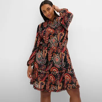 Paisley-Kleid mit langen Ärmeln und Rüschensaum in warmen Farbtönen.