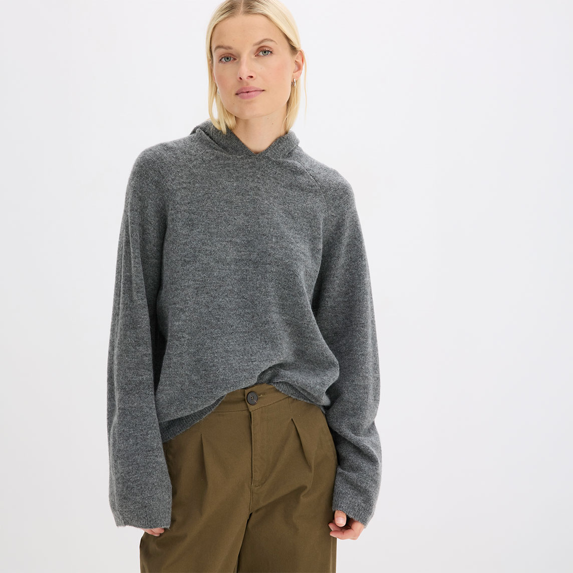 Stylischer Look mit bequemem grauem Strickhoodie und modischer olivgrüner Bundfaltenhose.