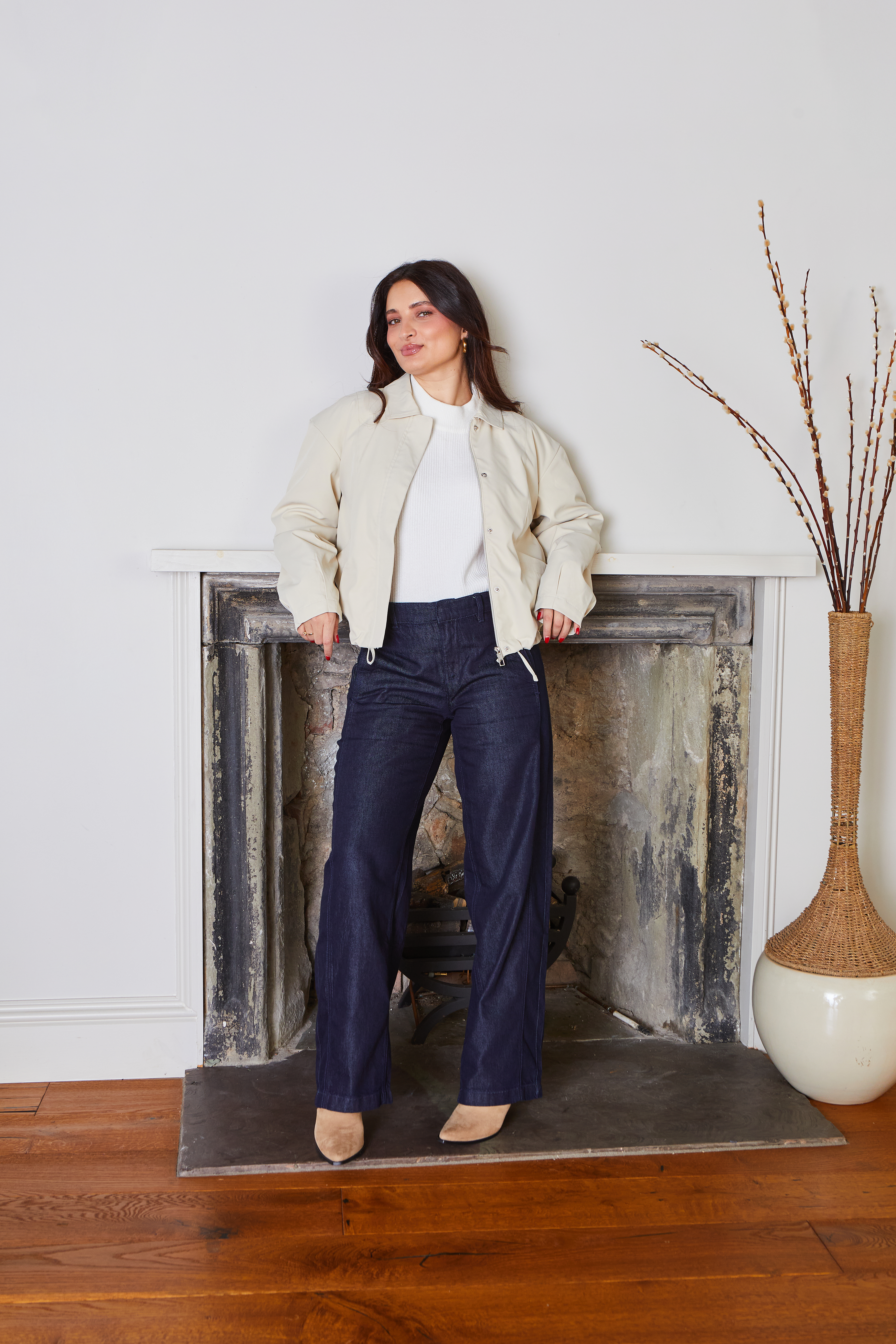 Helle Jacke über weißem Top, dunkle Jeans und Schuhe. Lässiger, zeitloser Look.