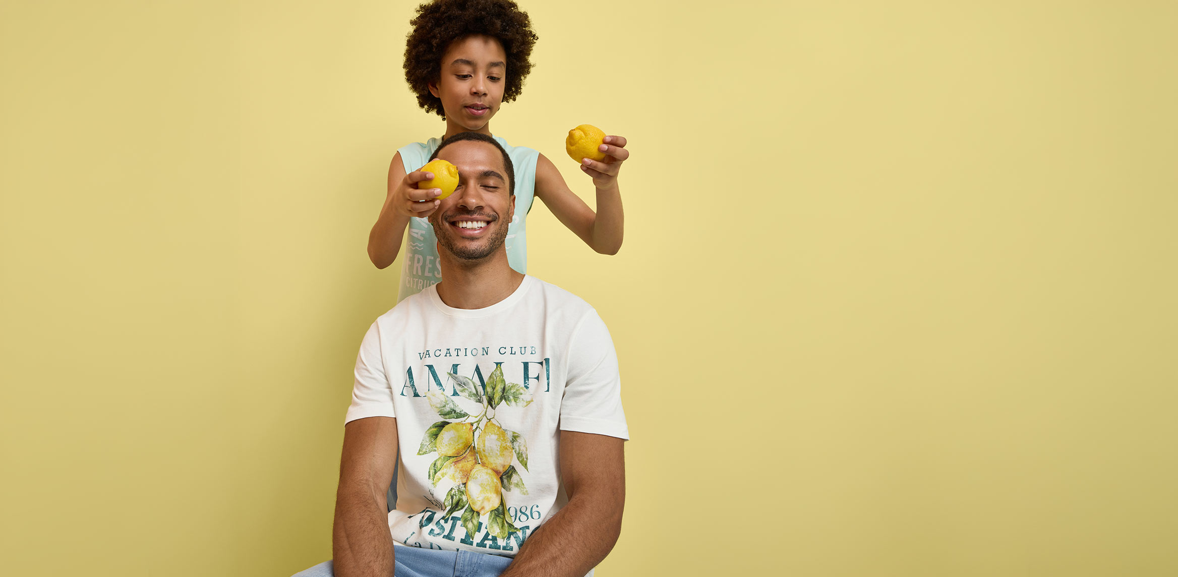 Mann und Kind tragen bunte T-Shirts mit Limonen-Motiven.