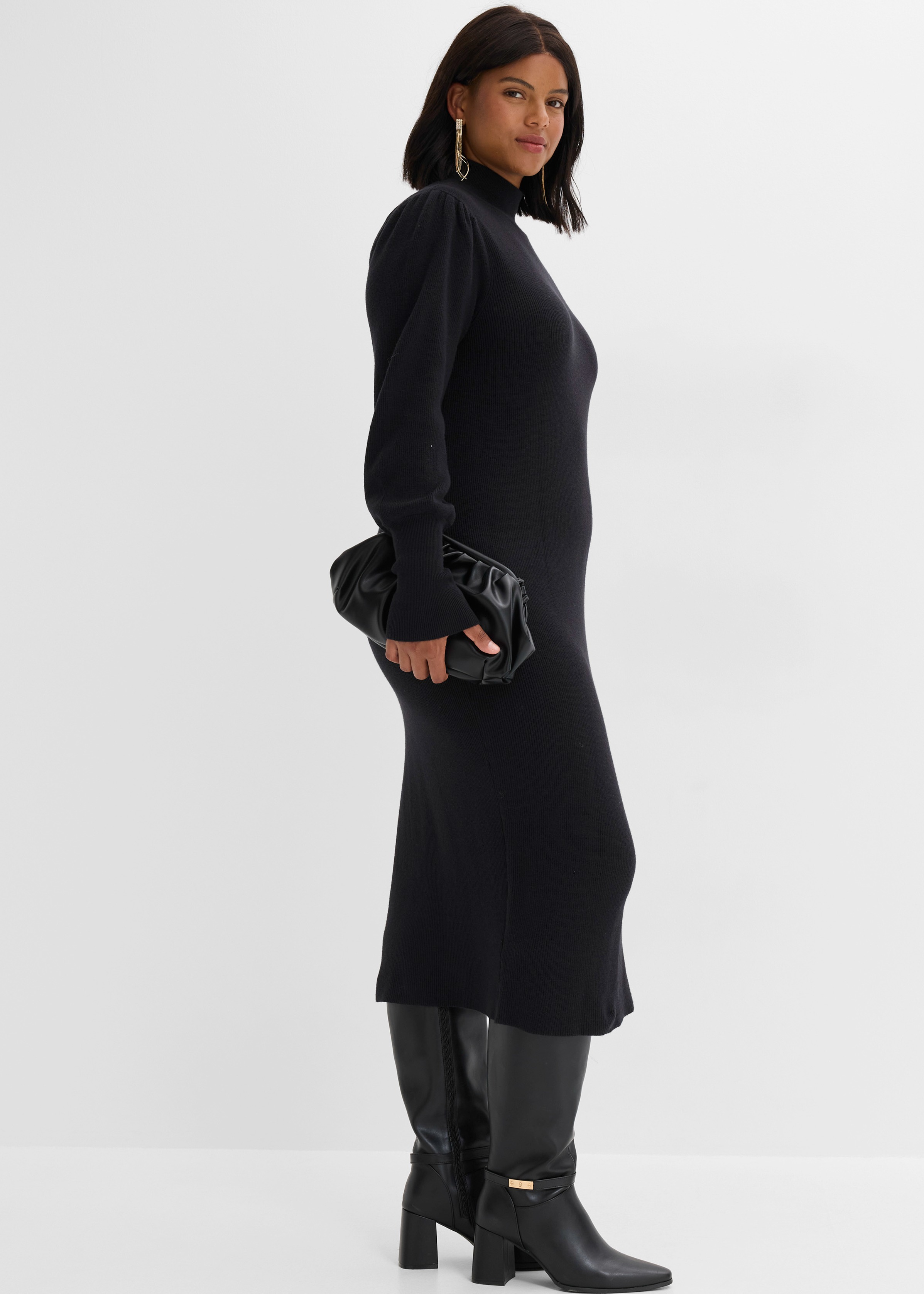 Modisches schwarzes Rollkragenkleid mit Puffärmeln, dazu hohe Stiefel und eine elegante Tasche.