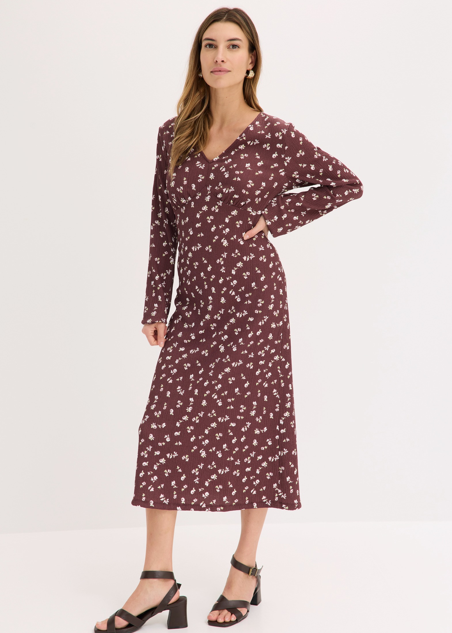 Weinrotes Blumenkleid mit langen Ärmeln und eleganten schwarzen Riemchensandalen.