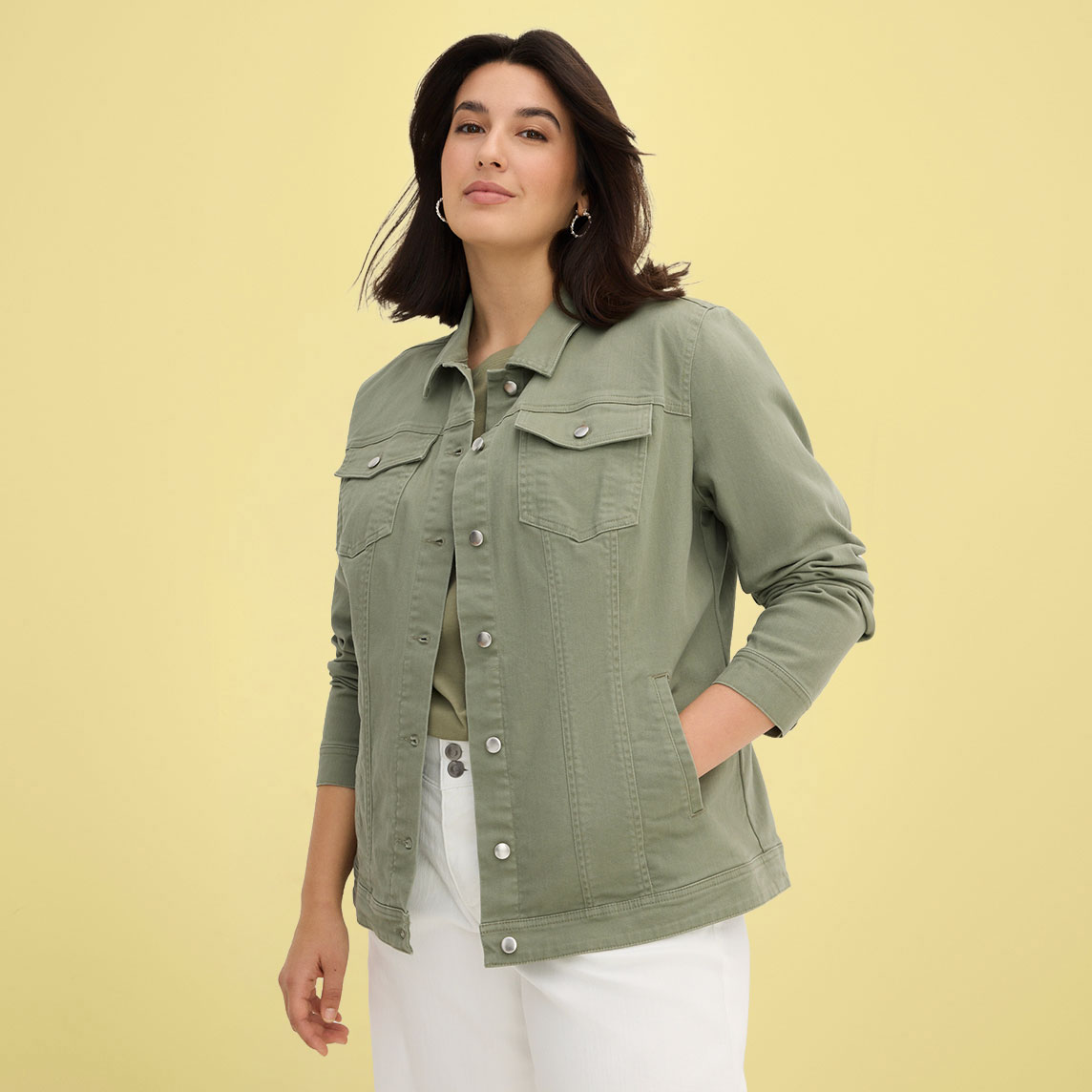 Olivfarbene Jeansjacke mit Brusttaschen kombiniert mit weißer Hose.