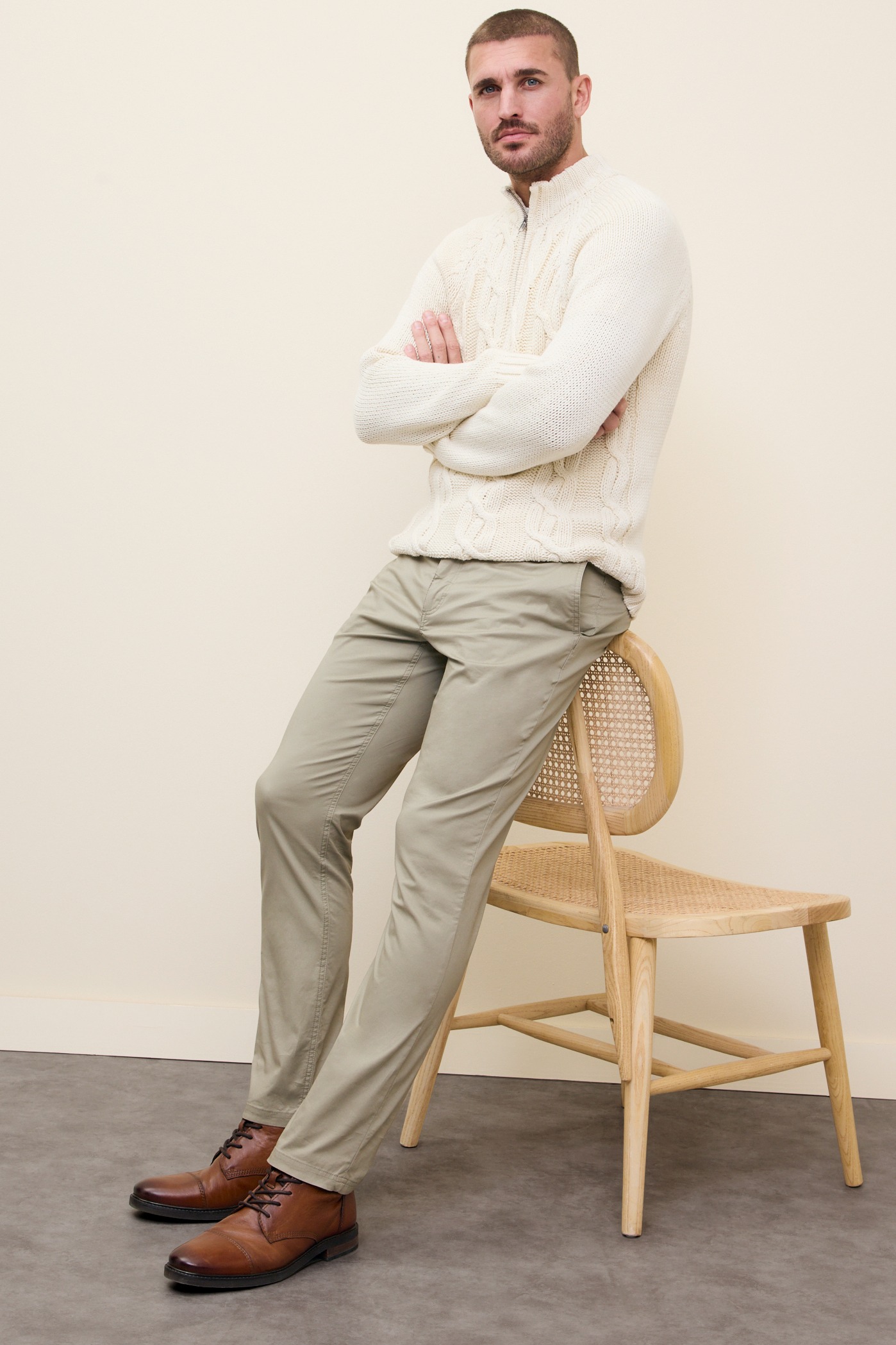 Eleganter weißer Strickpullover kombiniert mit beigen Chinos.