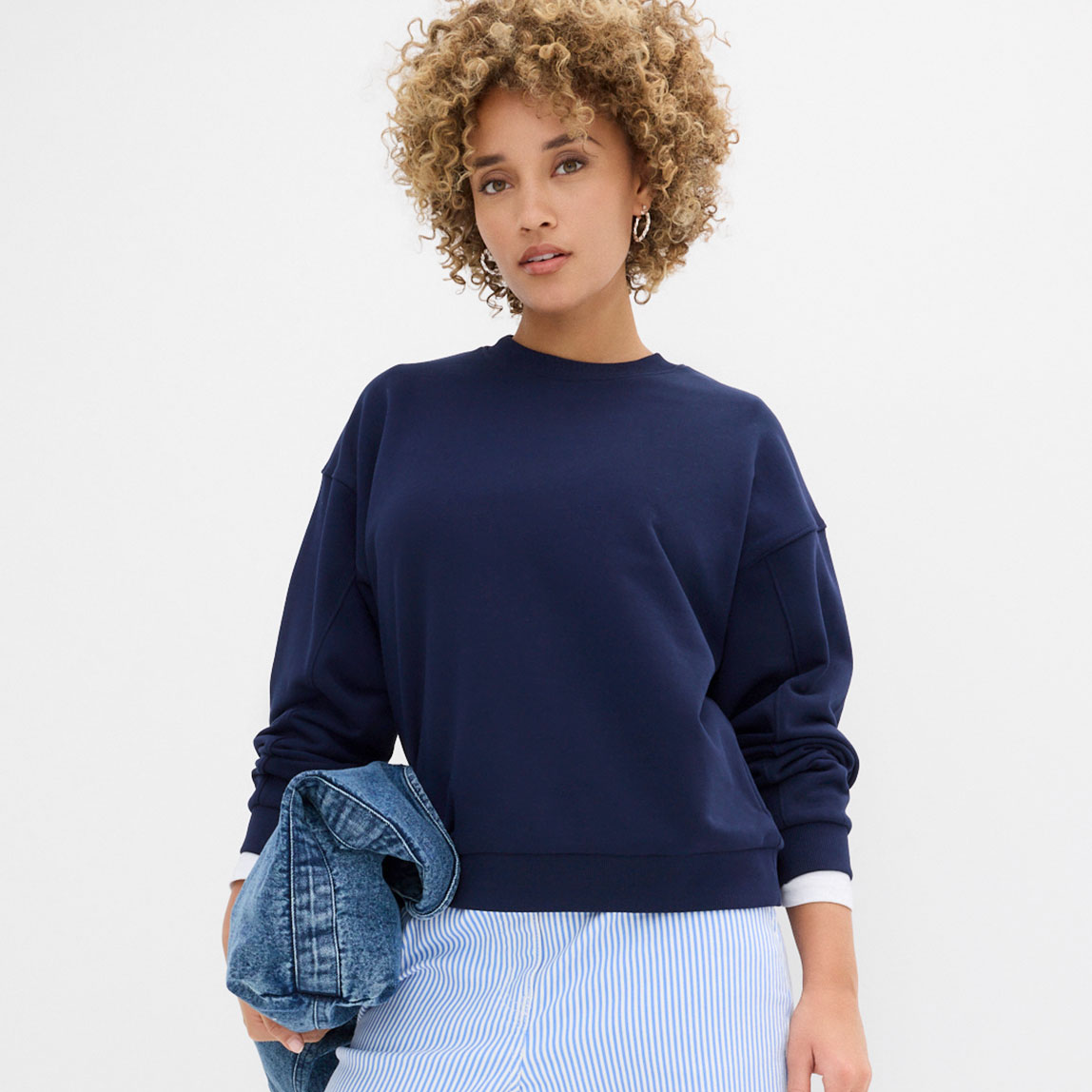 Blaues Oversize-Sweatshirt mit gestreifter Hose.