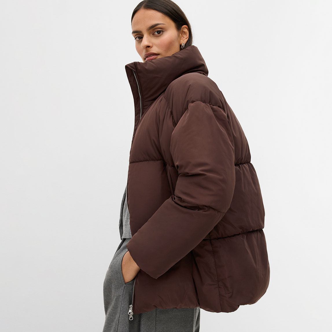 Braune Daunenjacke mit hohem Kragen.