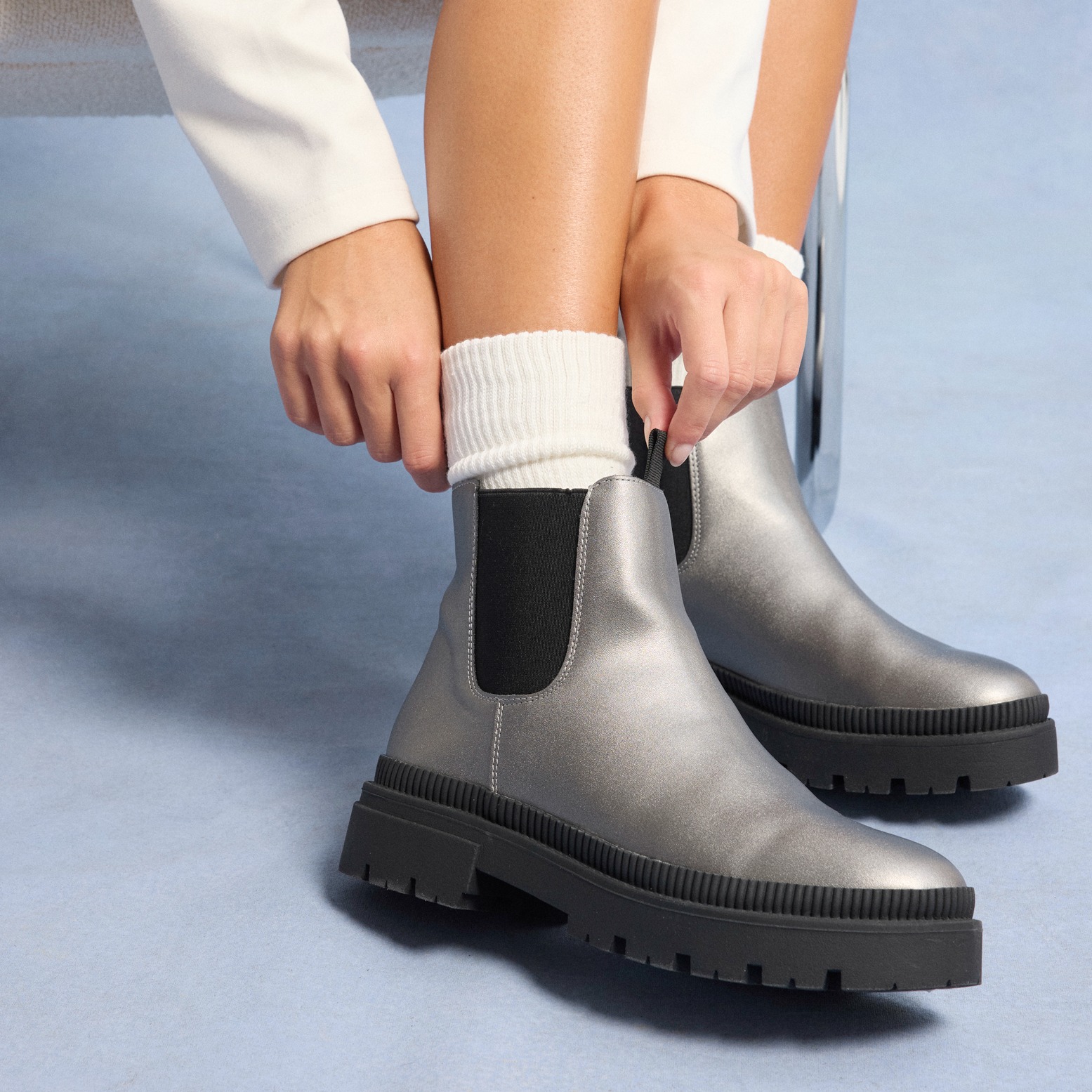 Silberne Chelsea-Boots mit robuster Sohle, kombiniert mit weißen Stricksocken.