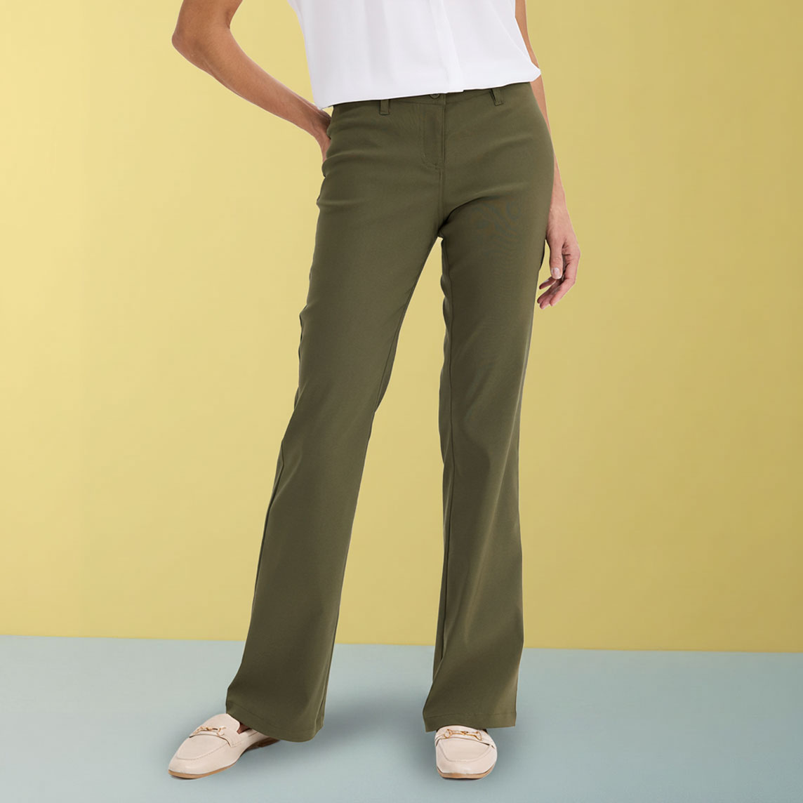 Elegante olivgrüne Hose kombiniert mit weißem Oberteil und beigen Schuhen.