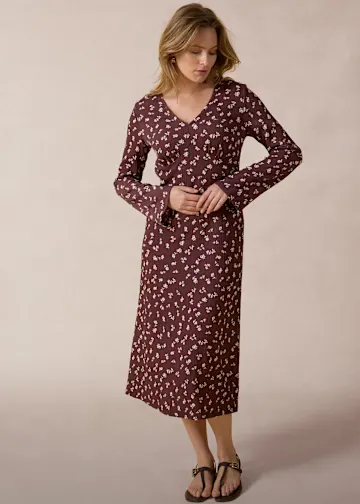 Weinrotes Kleid mit zartem Blumenmuster und weiten Ärmeln.