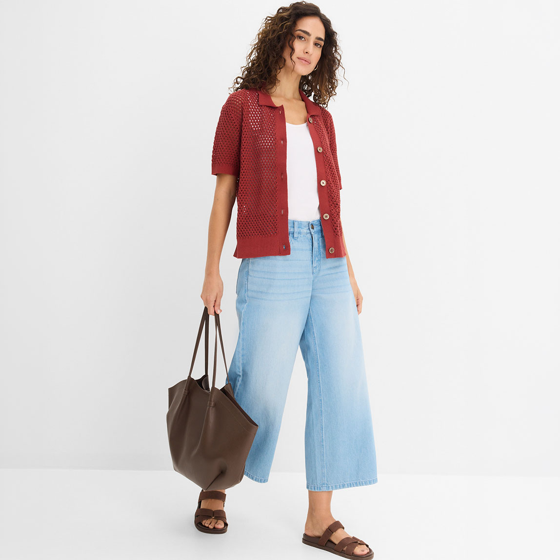 Rote Strickjacke kombiniert mit hellblauer Wide-Leg-Jeans und weißem Top.