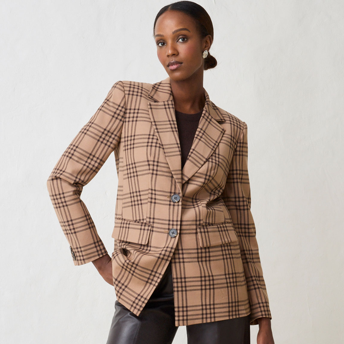 Karierter Blazer mit dunklem Oberteil und Lederhose.