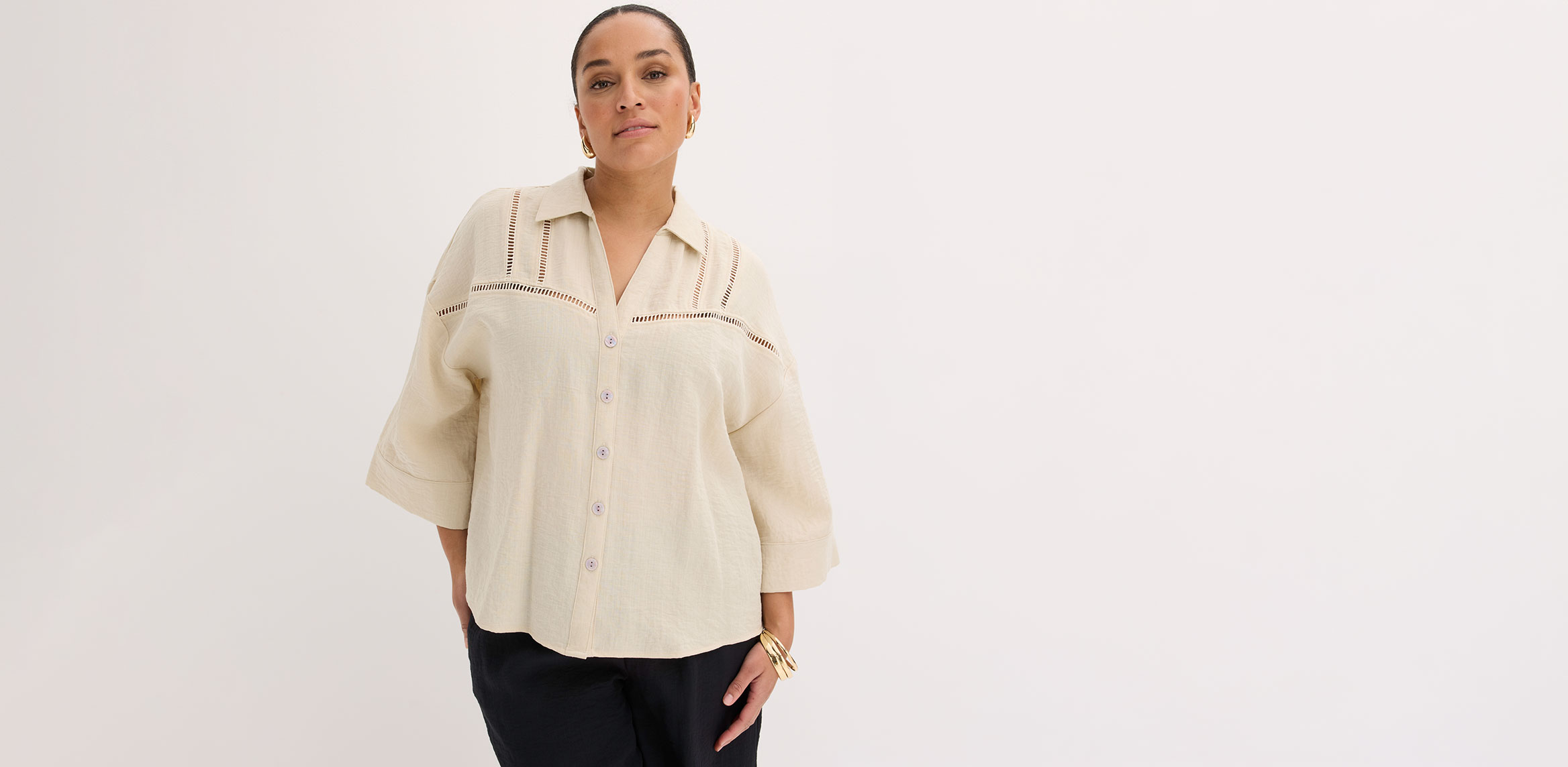 Cremefarbene Bluse mit klassischem Kragen, kombiniert mit einer schwarzen Hose.