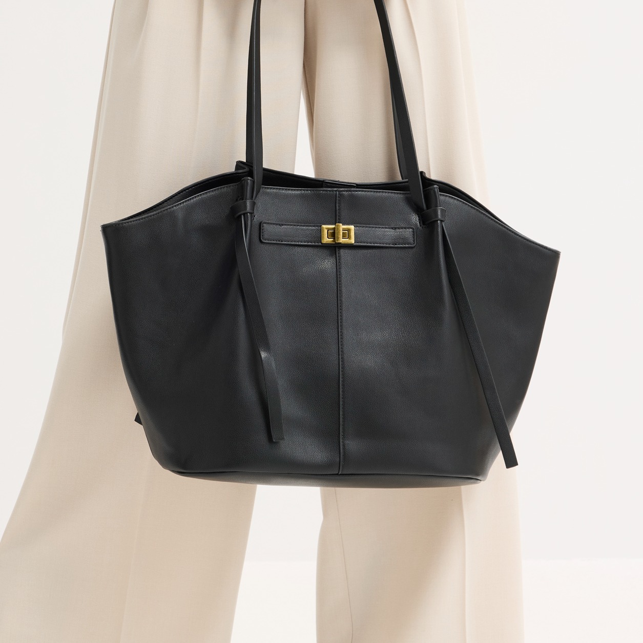 Elegante schwarze Tasche mit langen Henkeln.