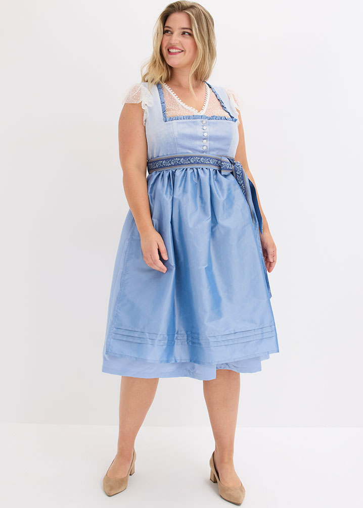 Hellblaues Dirndl mit weißer Spitzenbluse, gemustertem Schürzenband und eleganten Pumps.