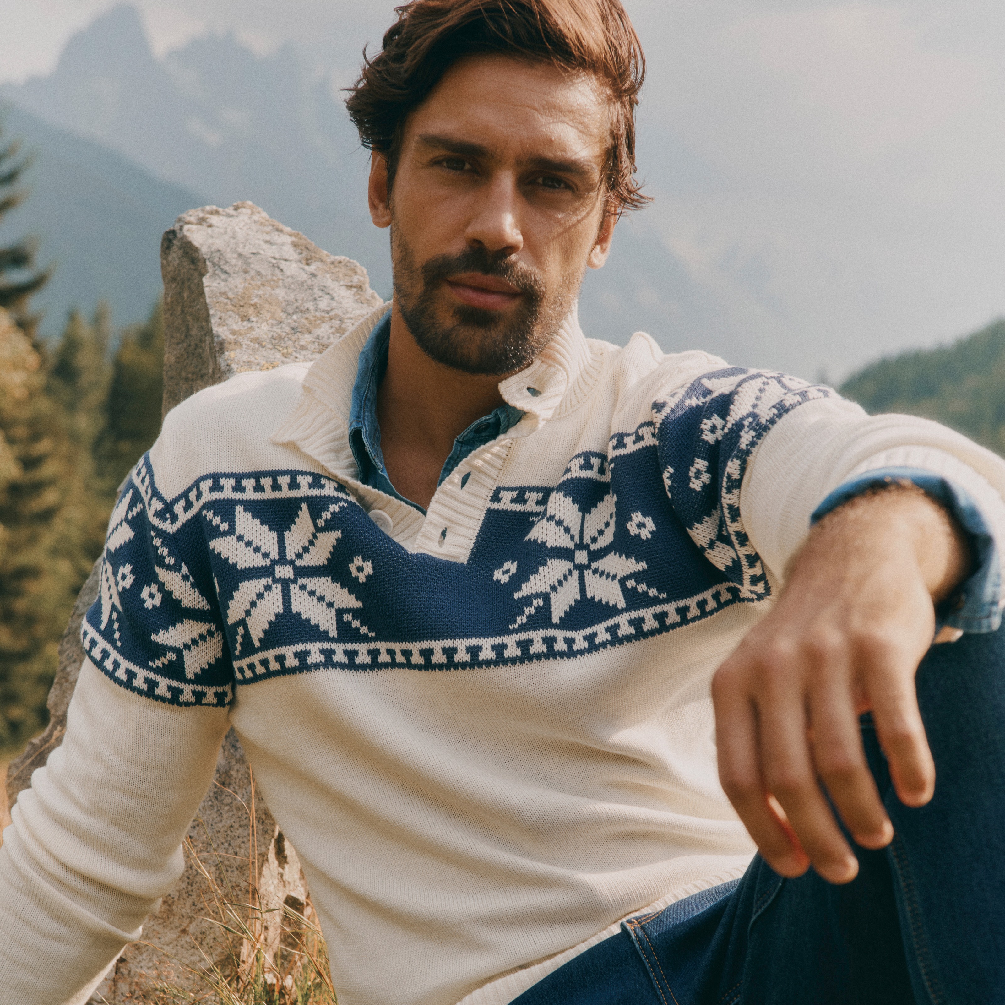 Warmer Strickpullover mit Schneeflockenmuster, kombiniert mit Jeans und Jeanshemd.