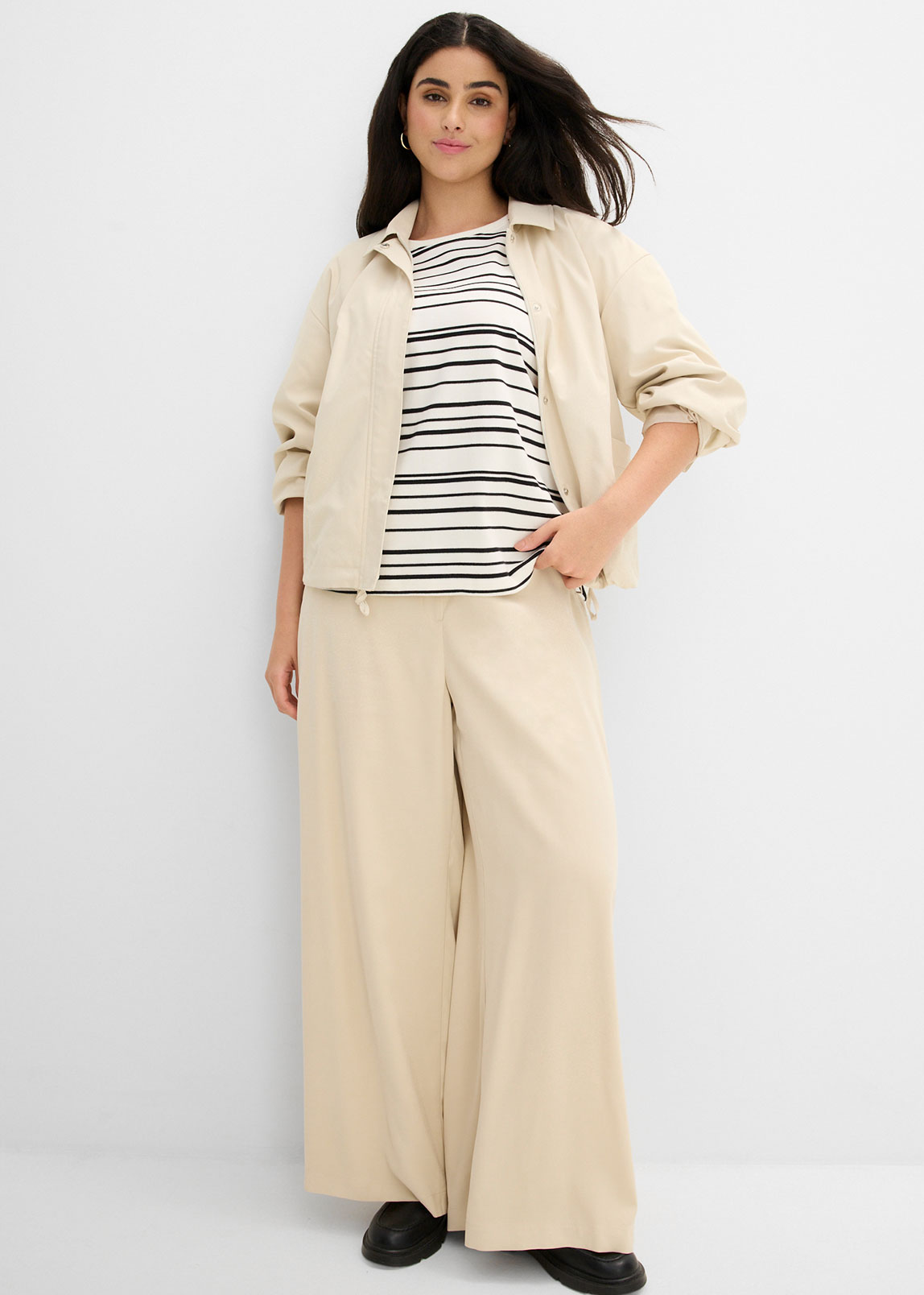 Beiger Blouson, gestreiftes Shirt und beige Palazzo-Hose.