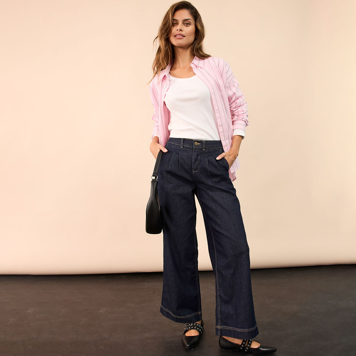 Rosa Bluse über weißem Shirt, kombiniert mit dunkelblauer Jeans.