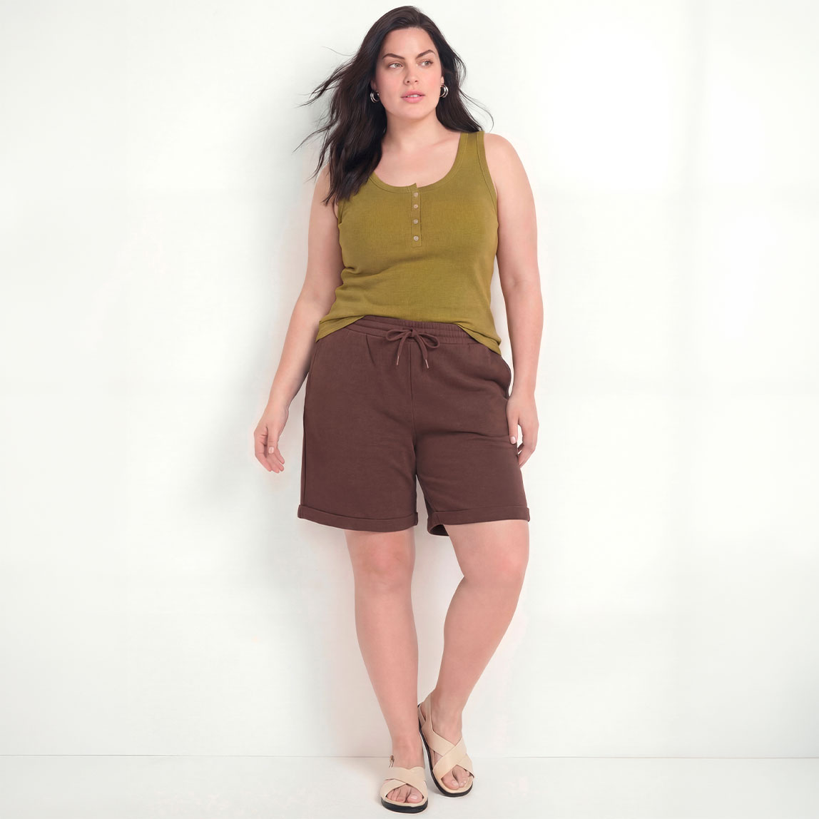 Olivgrünes Tanktop, bequeme braune Shorts und helle Sandalen.