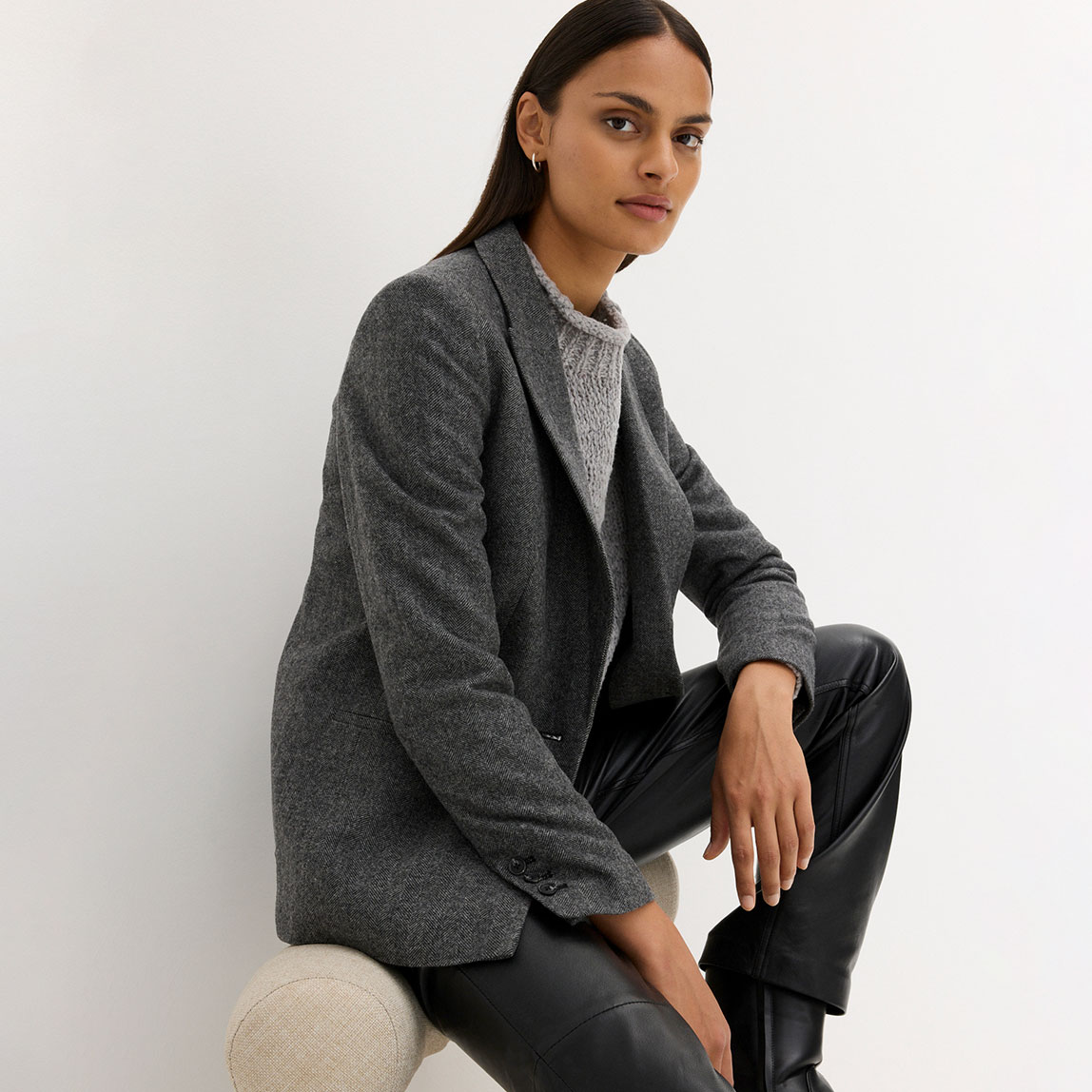 Eleganter grauer Blazer kombiniert mit dunkler Hose.